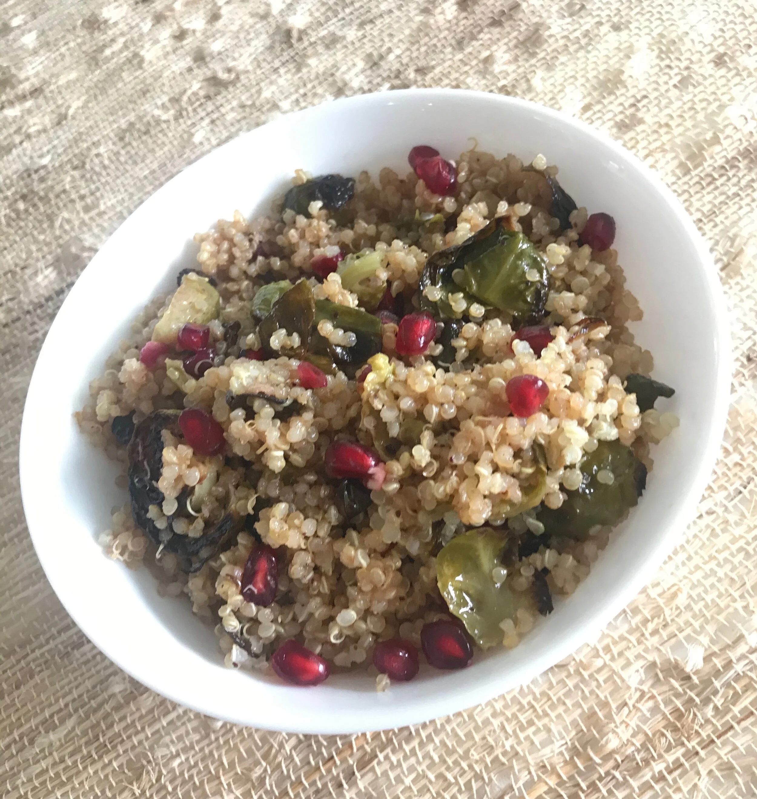 Quinoa with roasted brussels sprouts and pomegranate seeds in a bowl