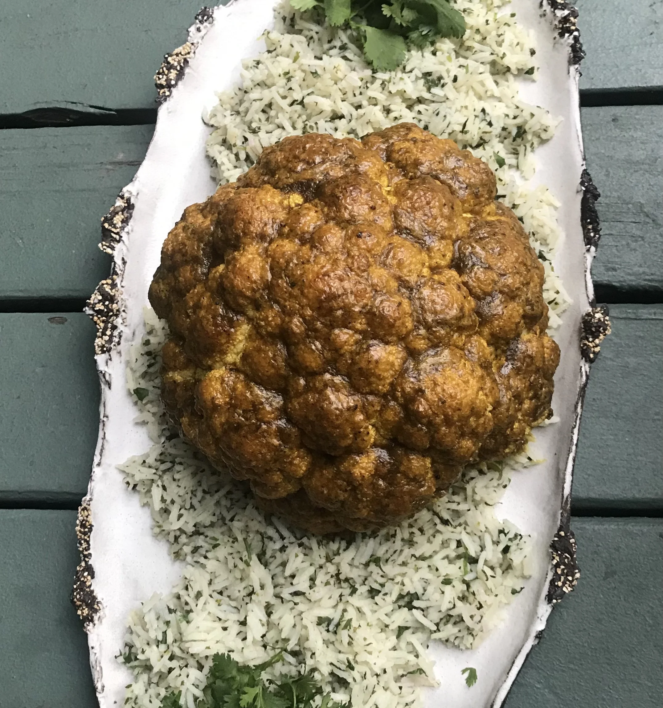 Whole roasted cauliflower coated in Massaman curry spices served with cilantro rice