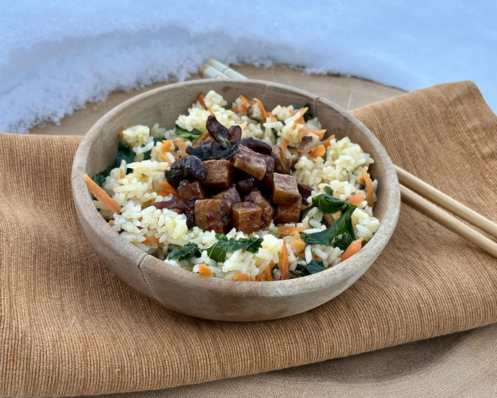 Tofu with cashews and sweet date sauce served over rice in a bowl