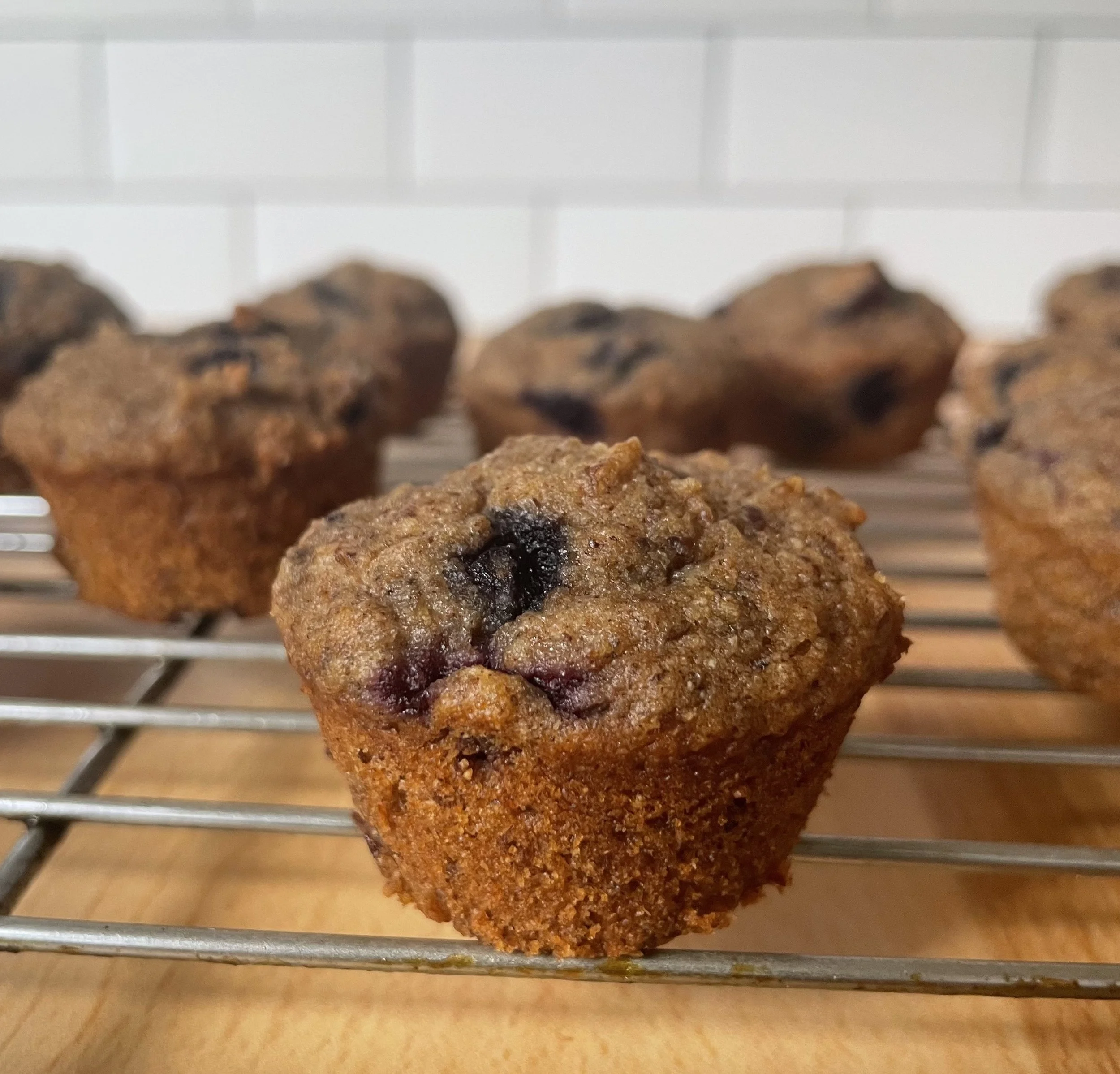 Freshly baked mini muffins cooling on a wire rack