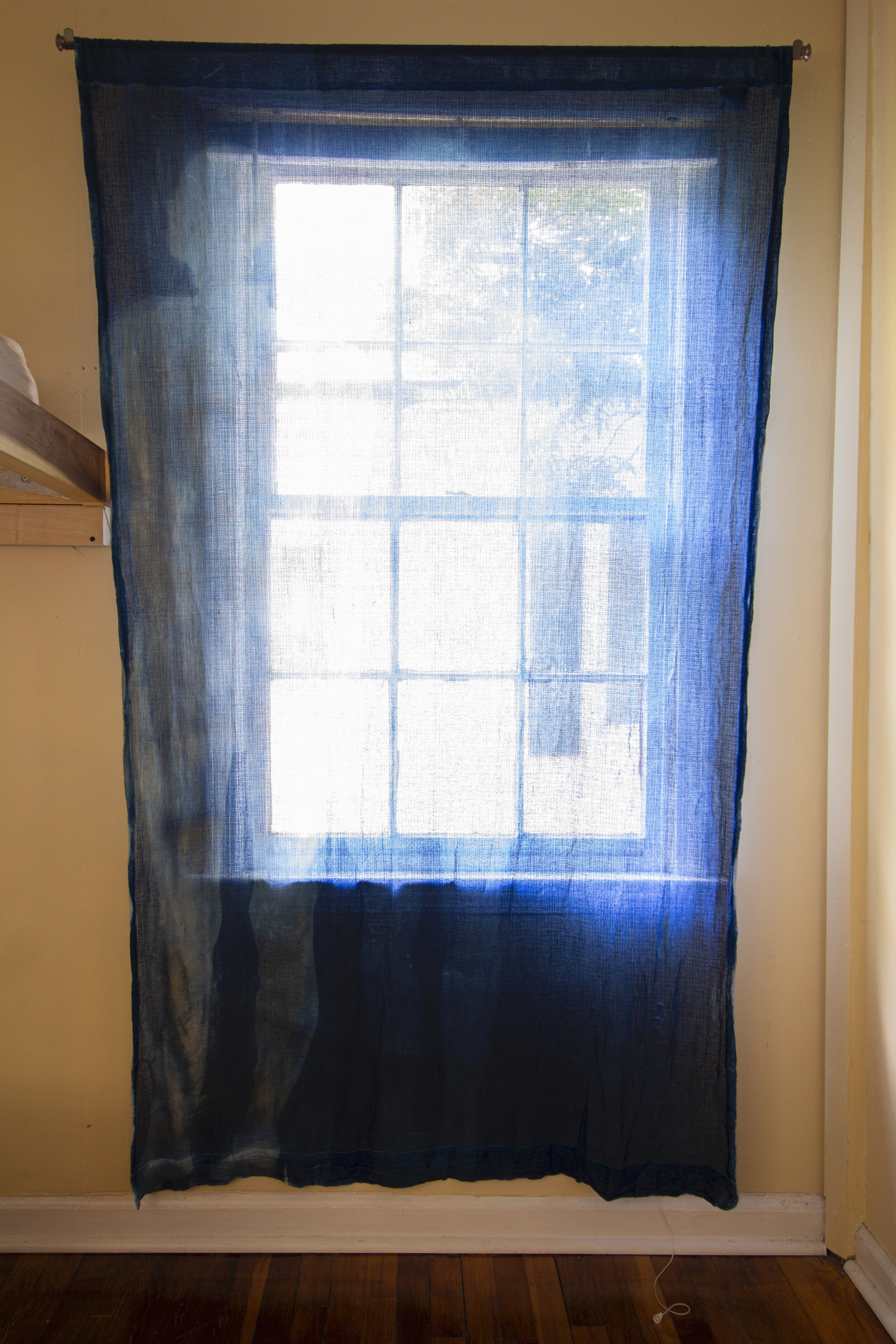  Unfolding [midday], 2020, cotton curtain, cyanotype solution, curtain rod, and hardware, 55 x 84 inches