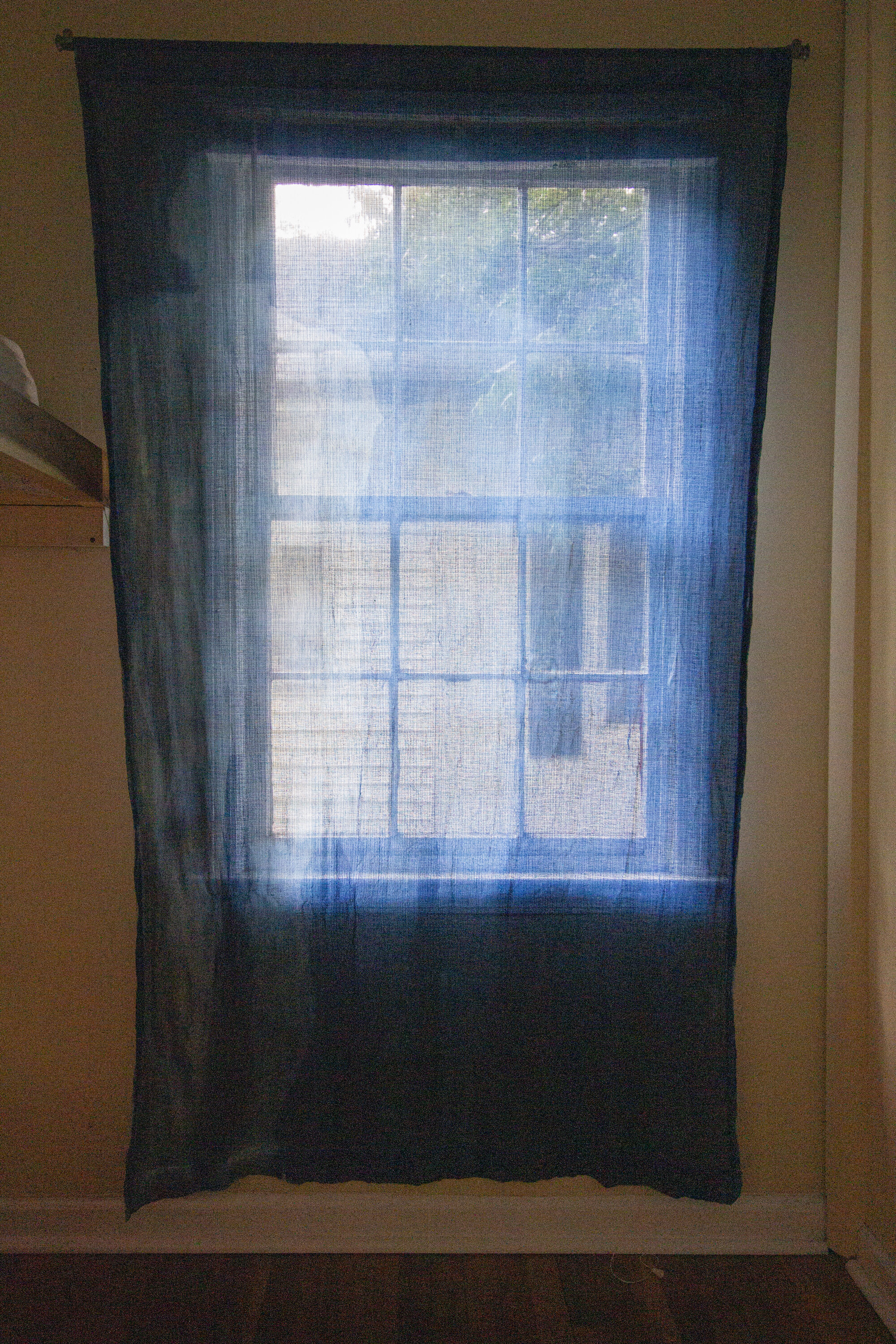 Unfolding [late afternoon], 2020, cotton curtain, cyanotype solution, curtain rod, and hardware, 55 x 84 inches