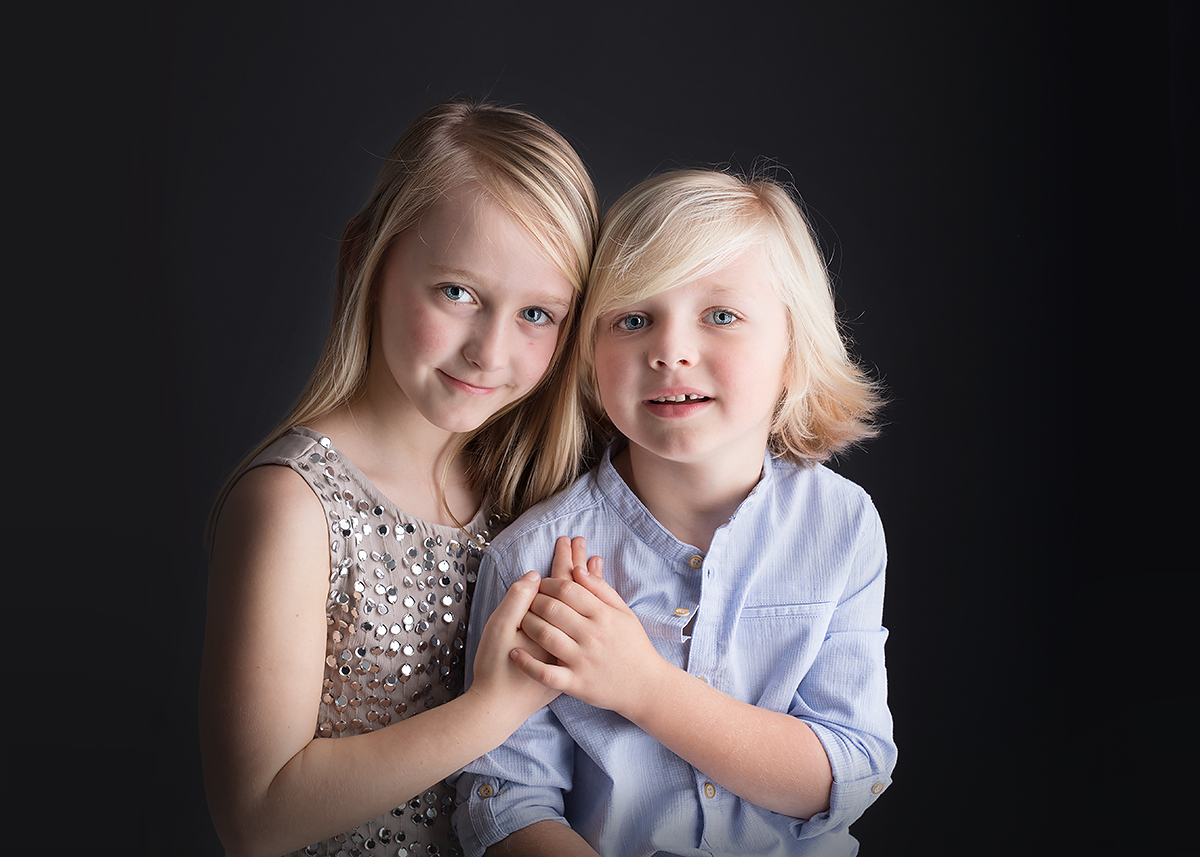 brother and sister on a black background at candace hires photography