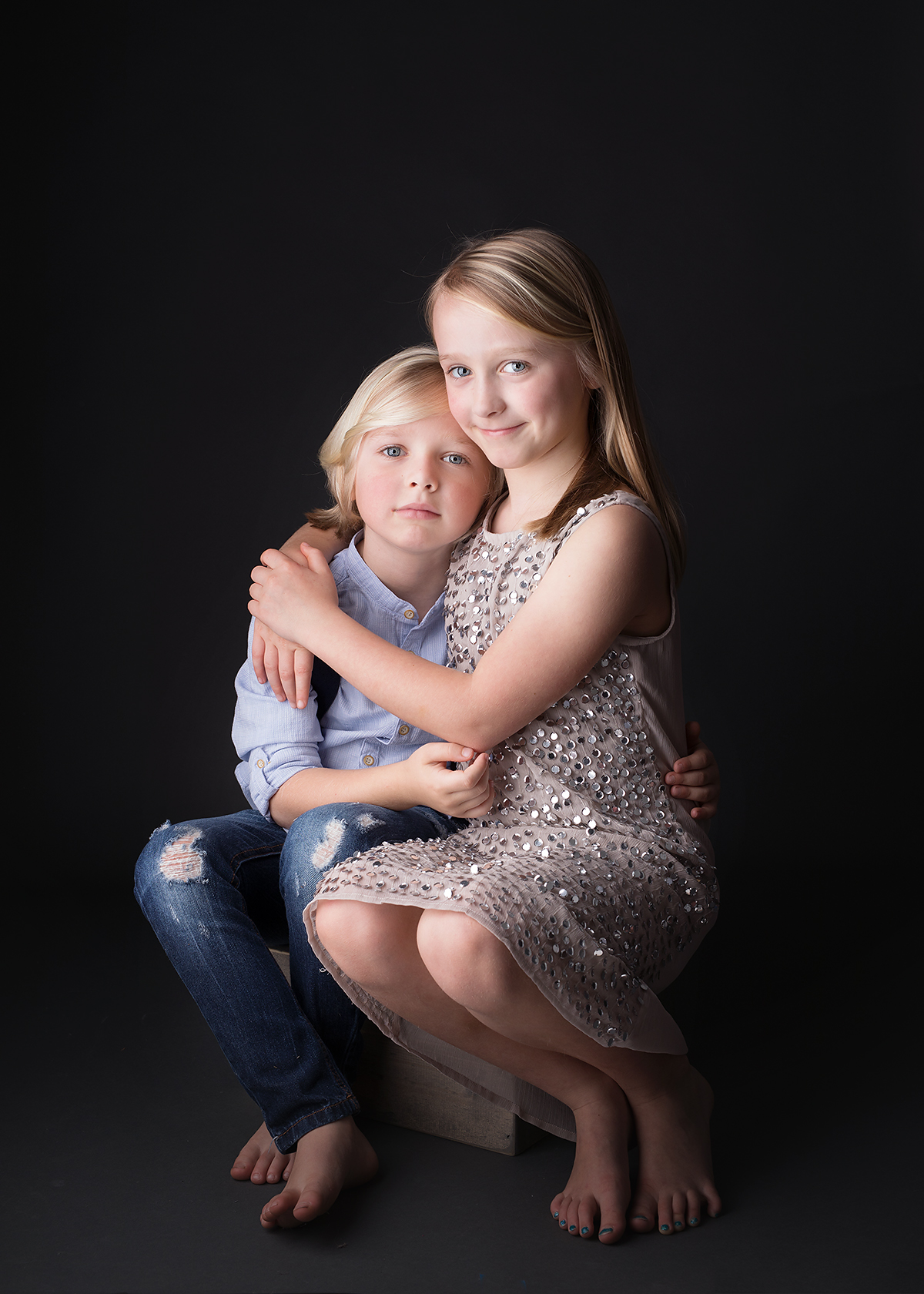 beautiful children siblings photographed in studio on a black background at candace hires photography