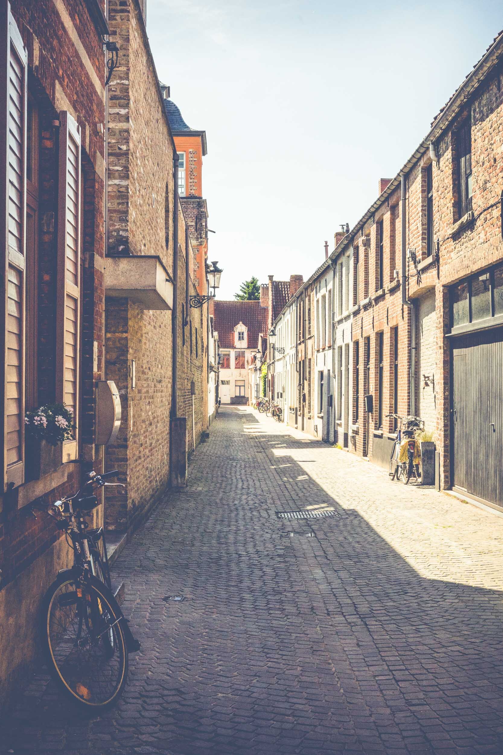 k Bike rests in shaded  alleyway with bright sun pushing down urban architecture street photography_.jpg