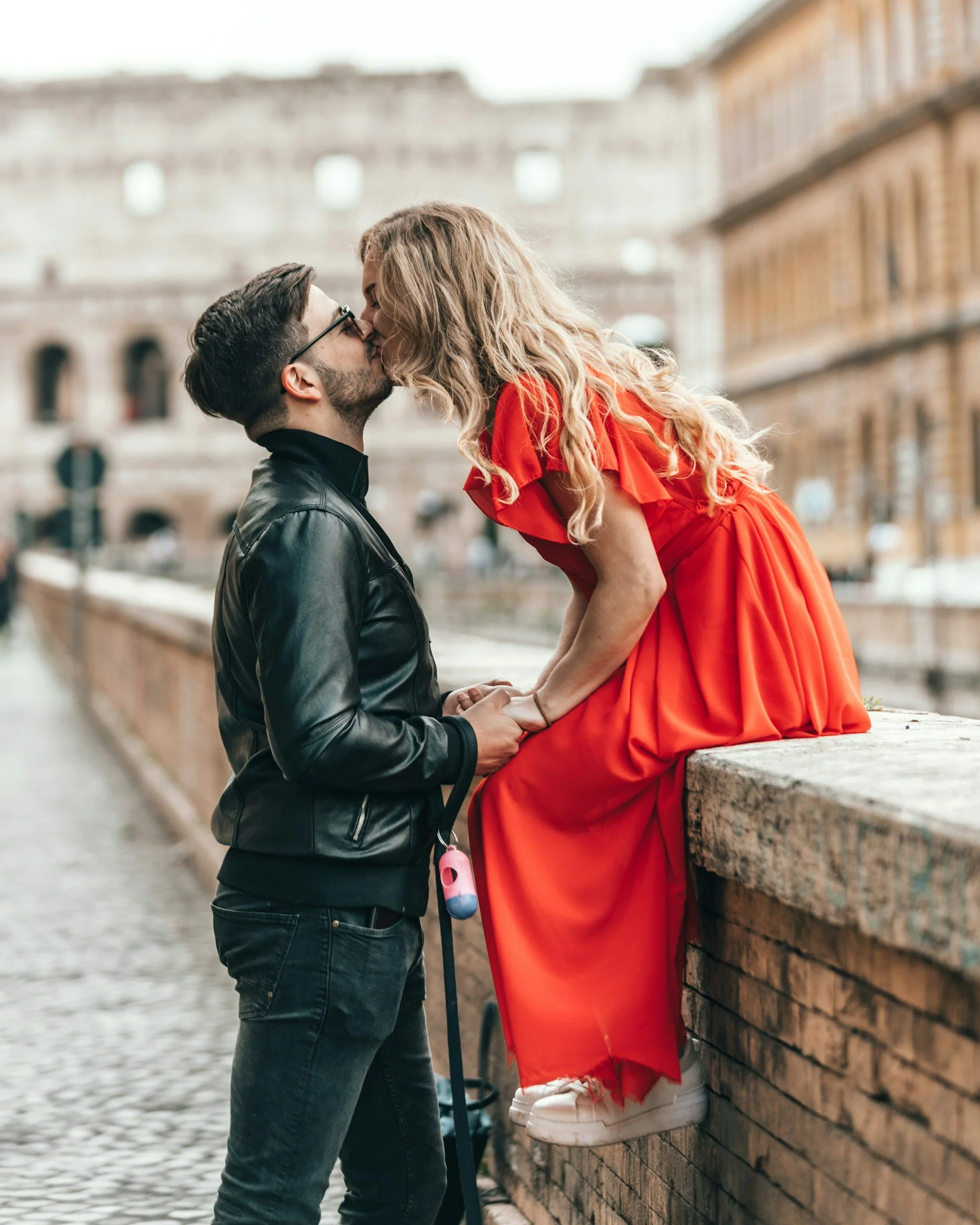 Couple kissing on a bridge in Rome on their honeymoon