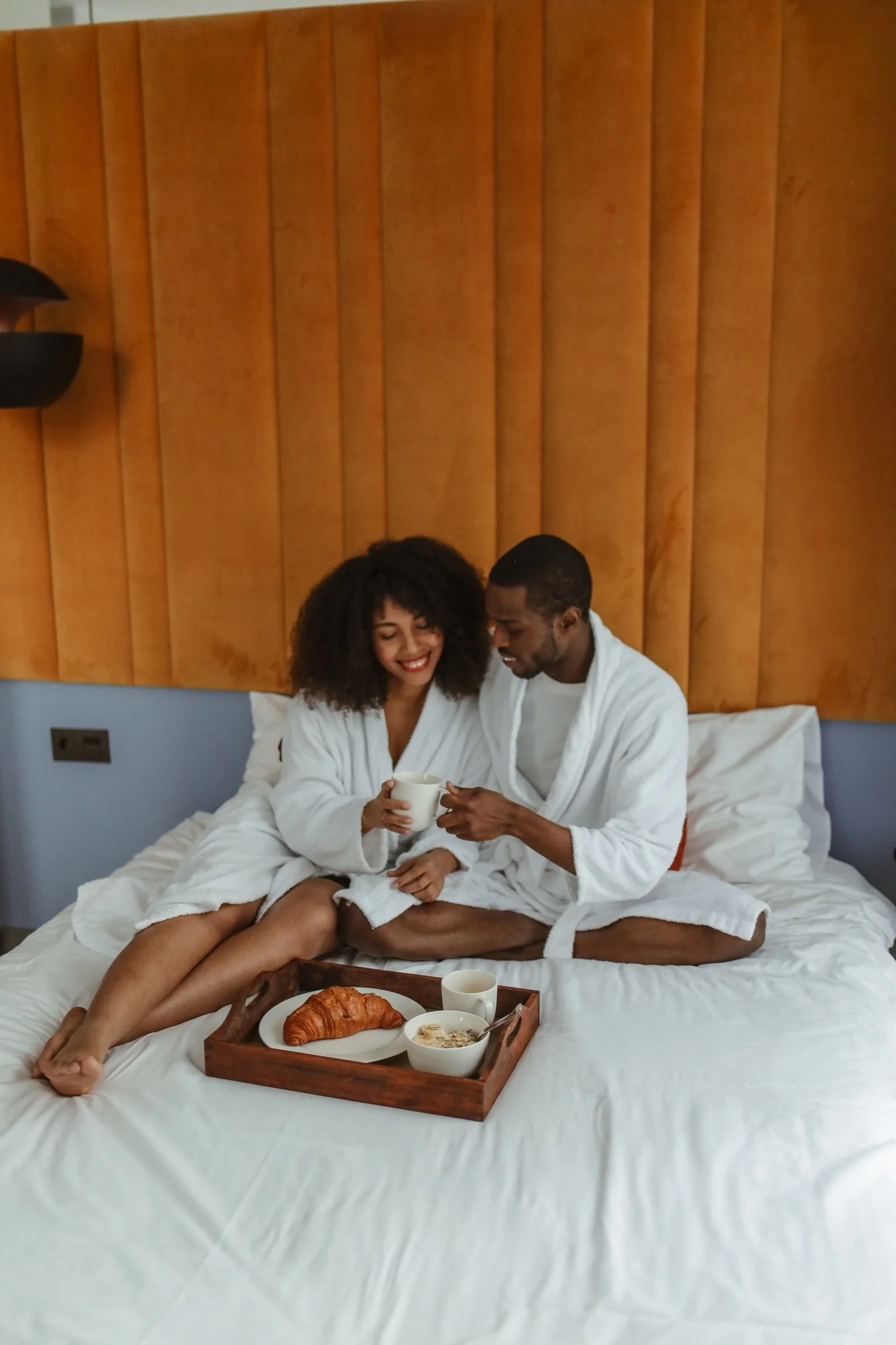 Honeymoon couple enjoying breakfast in bed at their Italian hotel