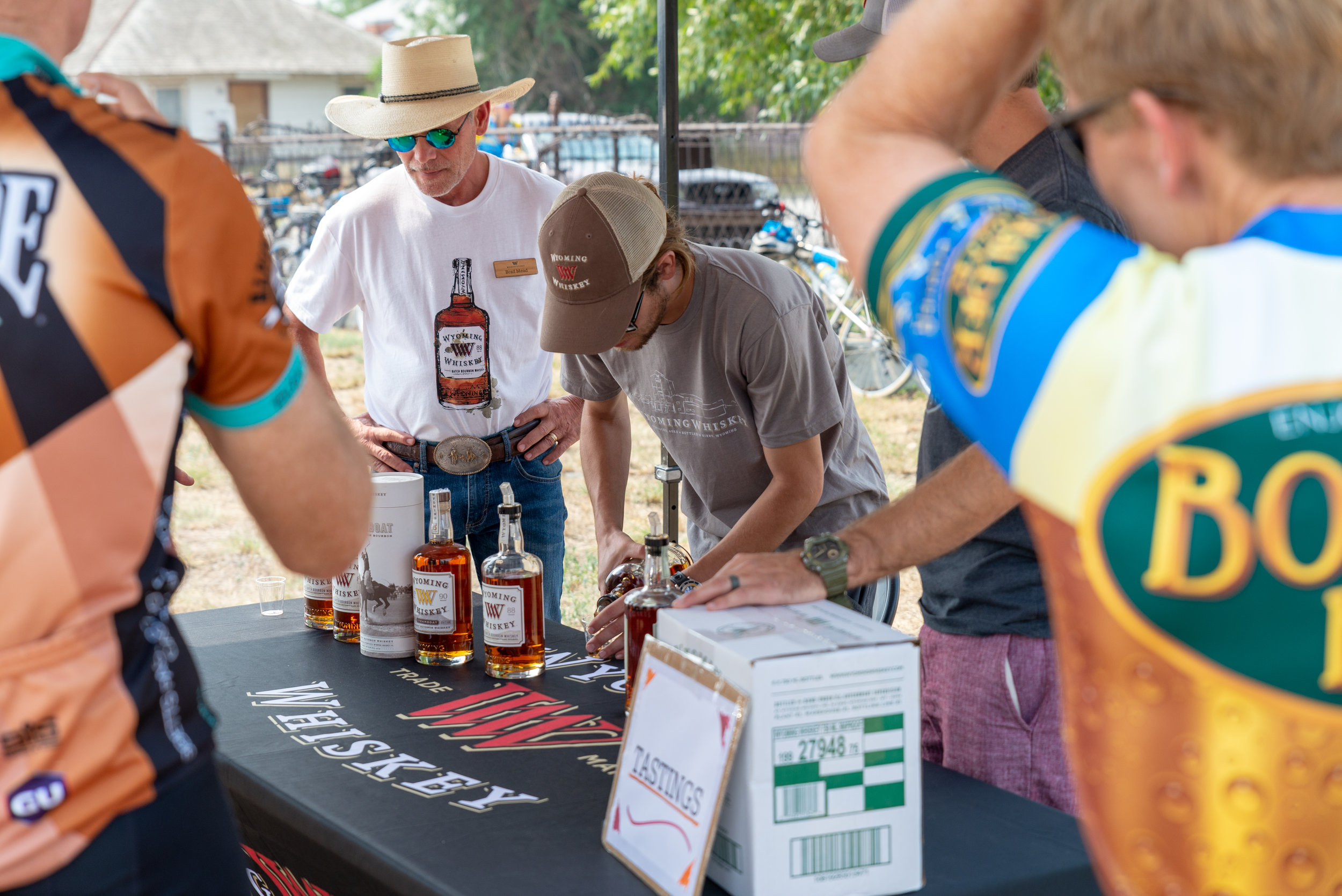 Wyoming Whiskey Distiller, Sam Meet pours samples for CGY Cyclists during the lunch stop in Kirby, WY. Photo by Nick Olson