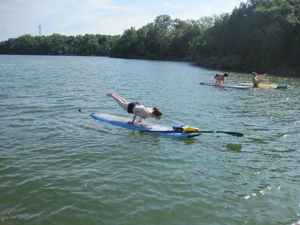 Kaci Wall practicing an arm balance on the water