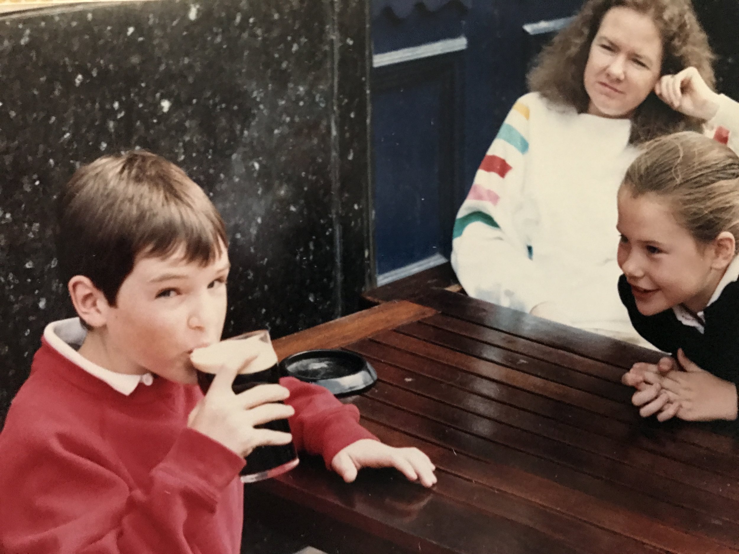 If this had been a movie, every principal involved and expression made in this shot could've been considered "foreshadowing" for the teenage years to come. My lovely mother, the one looking on here with disapproval, would probably like me to state for the official record that I was not granted permission to pound the Guinness you see in hand, my father who was behind the lens snapping the shot was letting me have the first foam-filled sip mostly for photo opp purposes. The actual pounding of Guinness would be at least a half decade later, while still another half decade after that away from when me and my man M Dawg would end up being paid to sell the dark magic of this deliciously Irish indigenous delicacy all around our local DC & Baltimore liquor store/bar clientele.