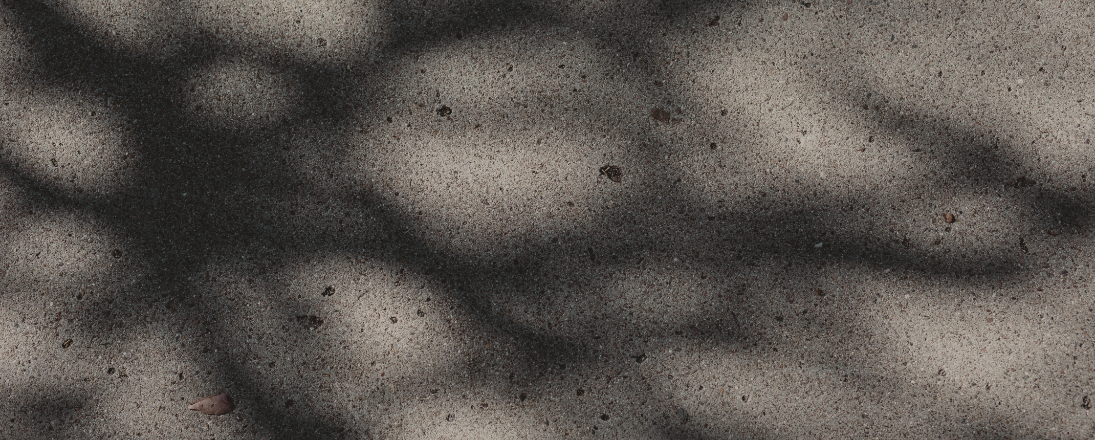 Lattice patter of light and shadows across a sidewalk