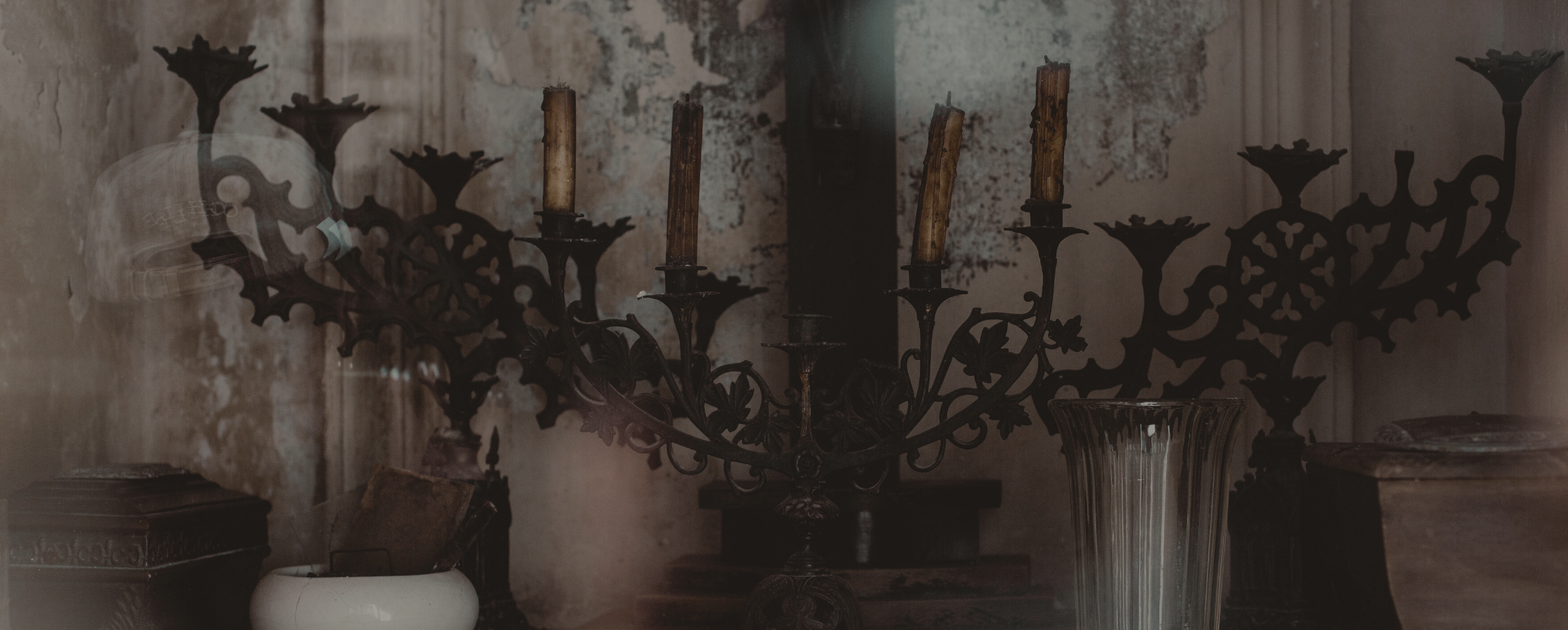 Candelabra with small boxes and a vase inside a mausoleum