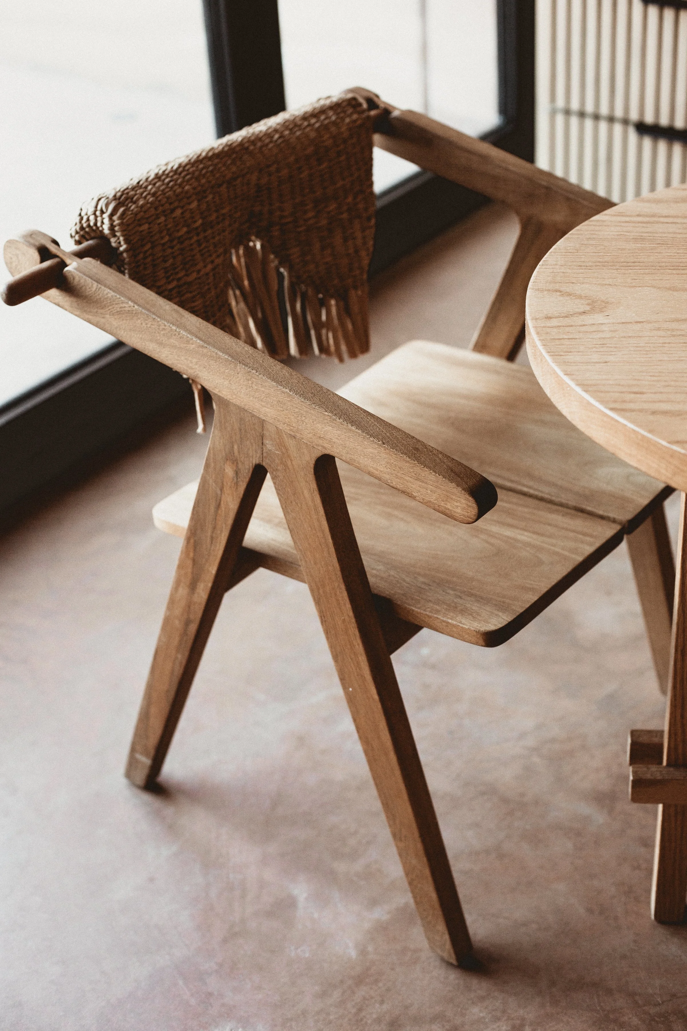 Wooden chair with woven backing next to round table