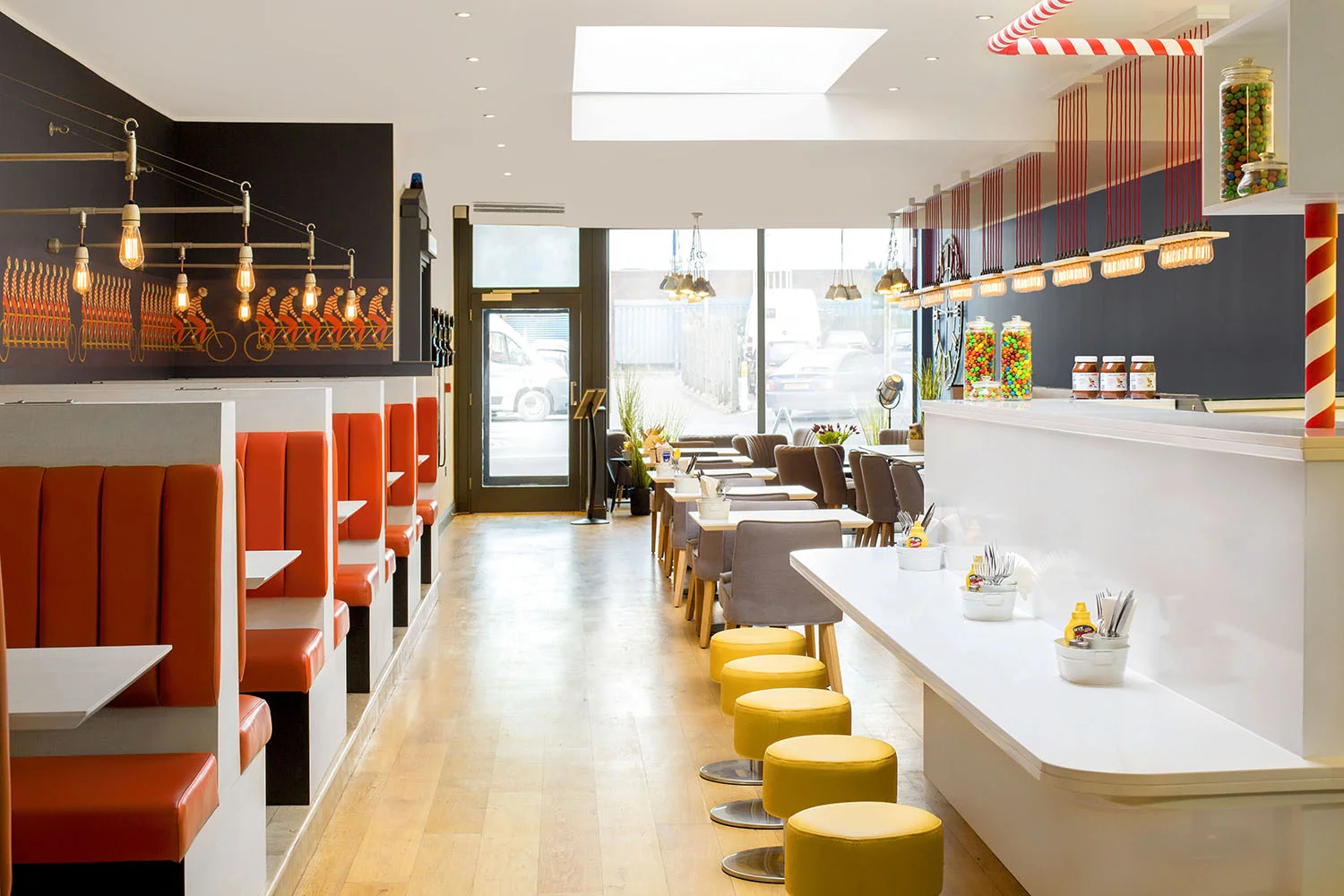  We can really see how Matteo has tied everything together here. Modern squirrel cage bulbs throughout the restaurant link the three different areas neatly with lighting.&nbsp;I love the candy stripe effect, a classic milkshake straw reference,&nbsp;which seemlessly integrates a support structure for floating box shelving units into the over colour scheme of the restaurant.&nbsp; 