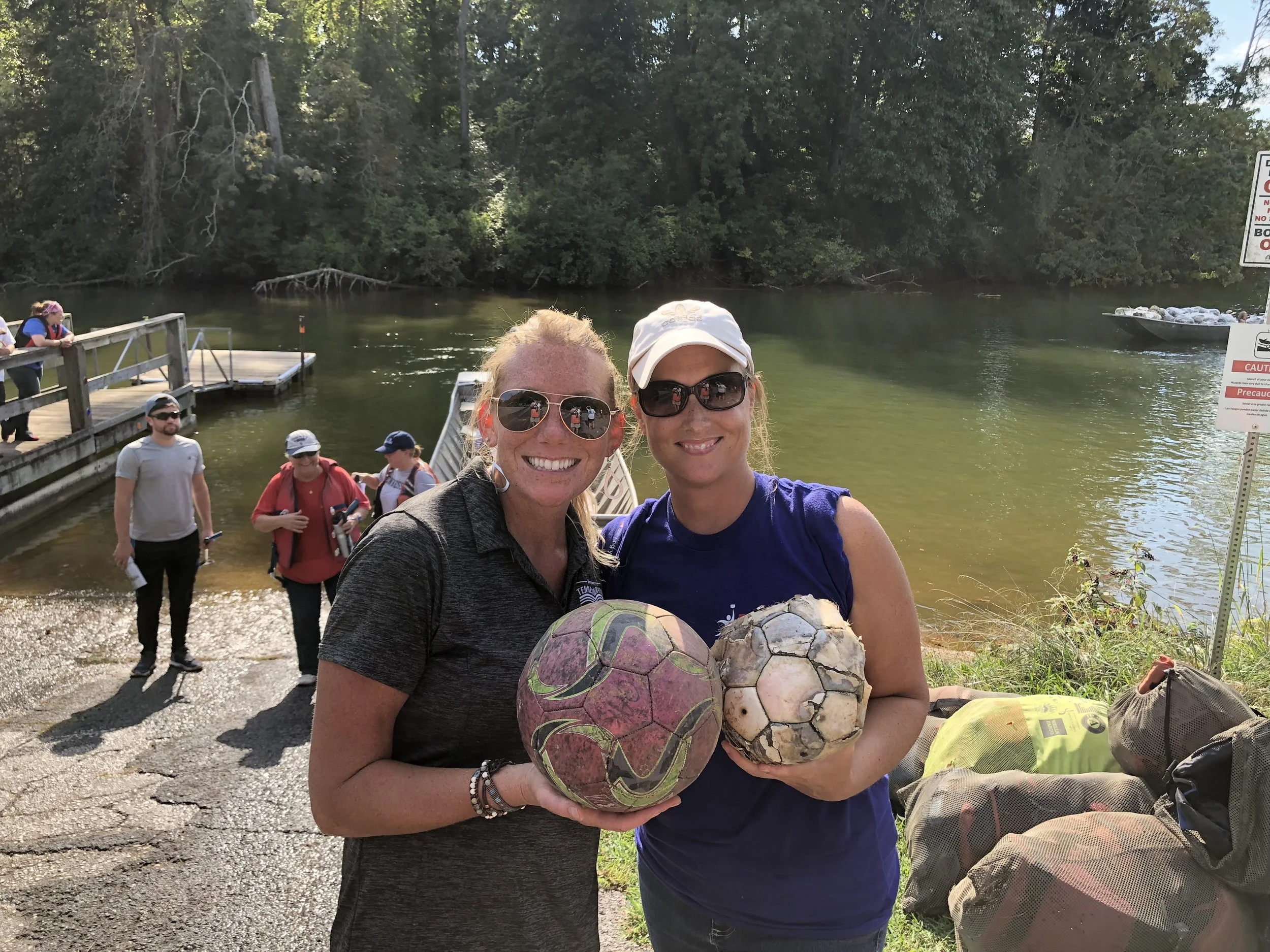 Laura Howard (left) and volunteer Lucretia Embry show off soccer ball treasures found in a KTNRB cleanup..