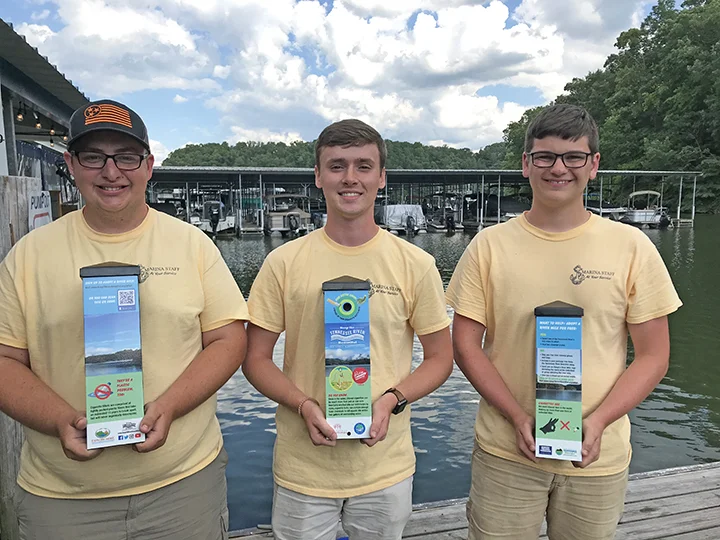 Staff at Caney Creek Marina show off their site’s new cigarette waste receptacles.