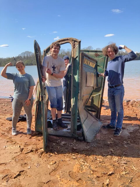 Volunteers pulled a full port-a-john that was partially buried in shallow water at the Knoxville/ Louisville, TN Cleanup on Sunday.