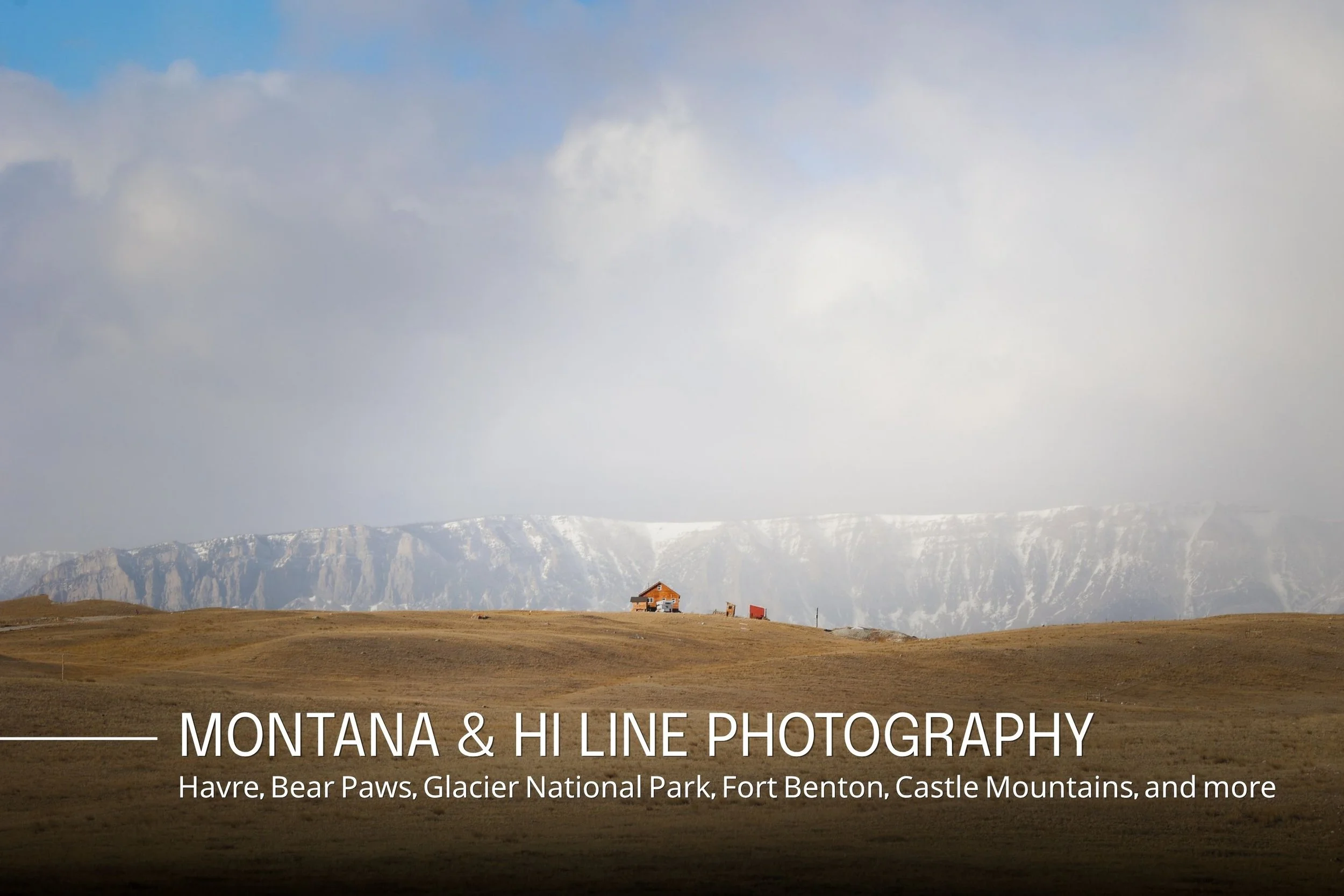 Wide view of Montana landscape with grassy plains, a small house, mountain range in the background, and cloudy sky.