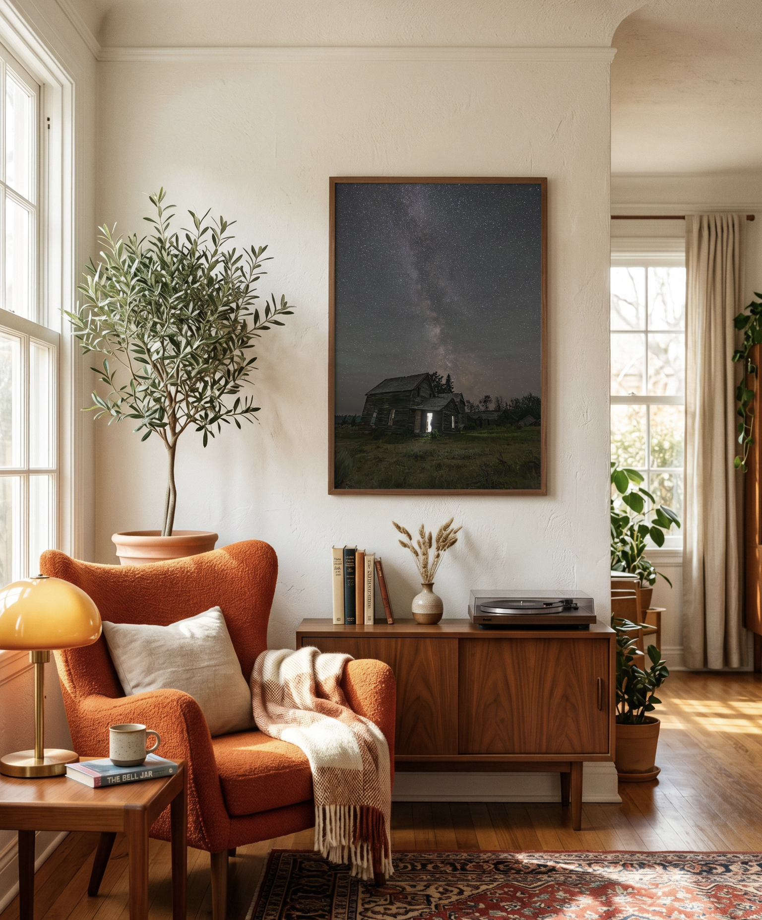 Living room corner with orange armchair, white pillow, cozy blanket, side table with lamp and books, large potted plant, and a framed photo of a starry night sky on the wall. Sunlight streams through windows with beige curtains.