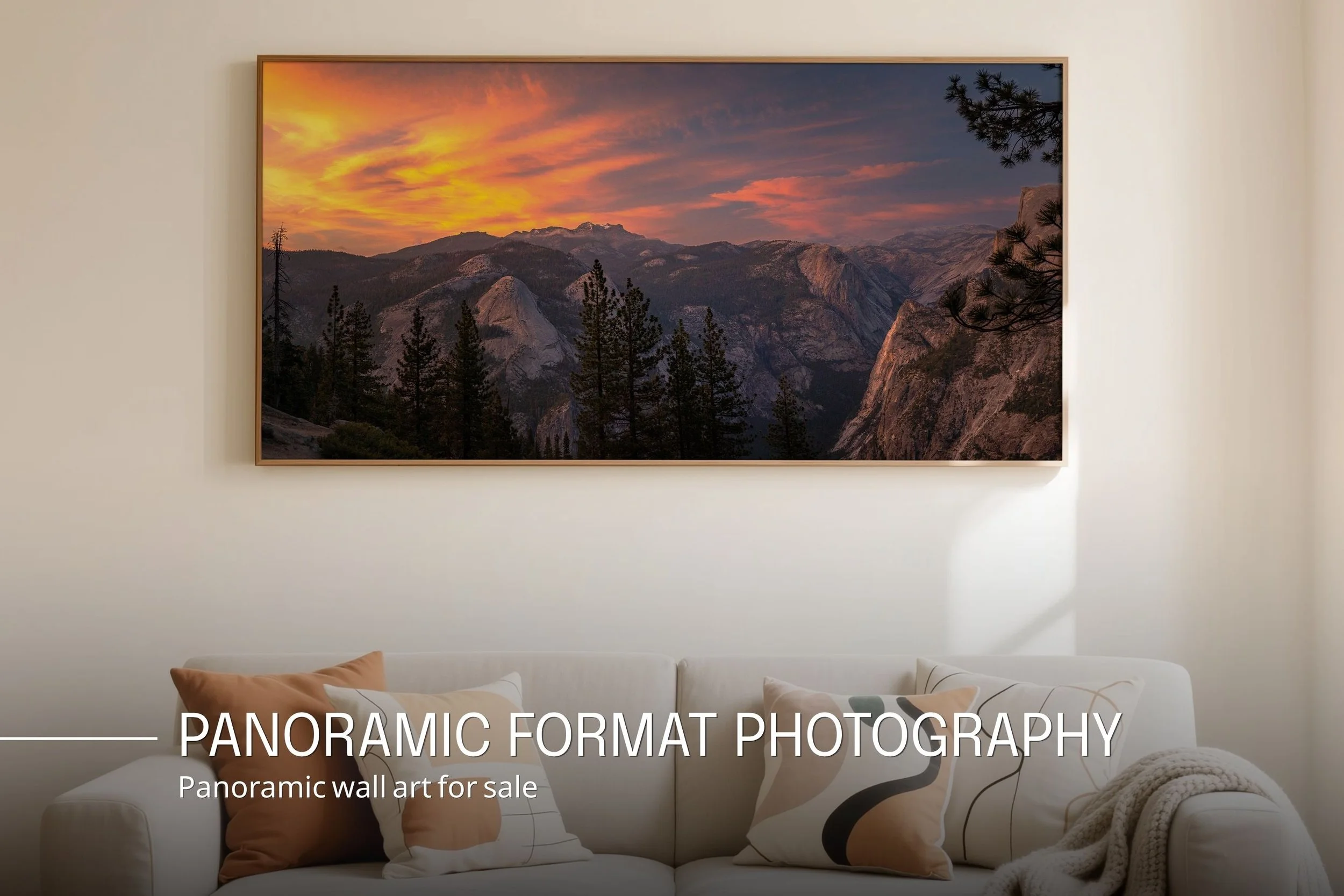 Living room with a sofa decorated with various pillows and a large panoramic landscape wall art of mountains and a colorful sunset.