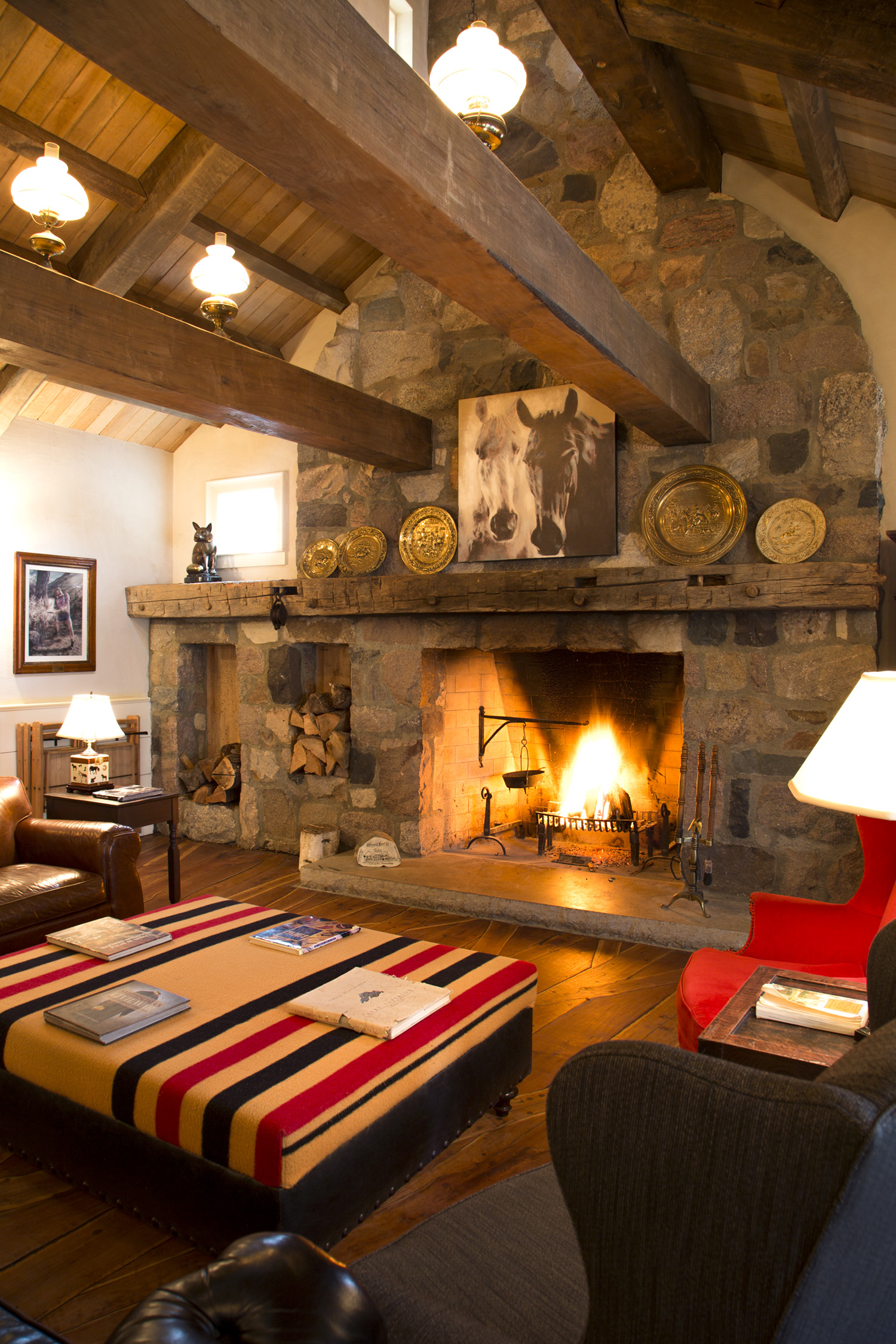 Fireplace Room The fireplace room is one of the coziest spaces to kick your feet up with a hot cup of coffee or refreshing Mint Julep. The stones used to construct the breathtaking fireplace are from the foundation of an 1840s Dryden dairy barn, donated by owner Greg Kesselring. The Giddings Family Stone Masons of Millington reproduced the wide grout joints of the original structure. The large market table behind the couch is an antique from an 1870s Vermont country store. The wrought iron fireplace grate, crane and kettle are the oldest pieces in the building, originally from New England circa 1780! The ottoman was created using a classic Newmarket blanket, still used by equestrians today. Its design hasn't changed since the 1700s when they were used on race horses in Newmarket, England.