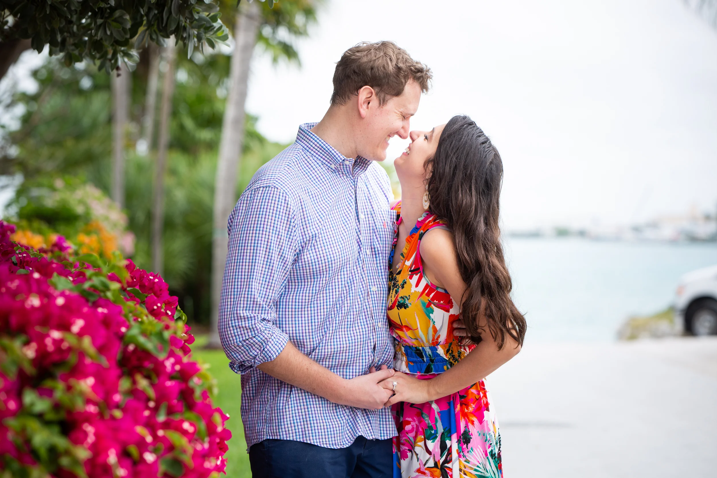 Couple giggling at each other with pink flowers on Sunset Key
