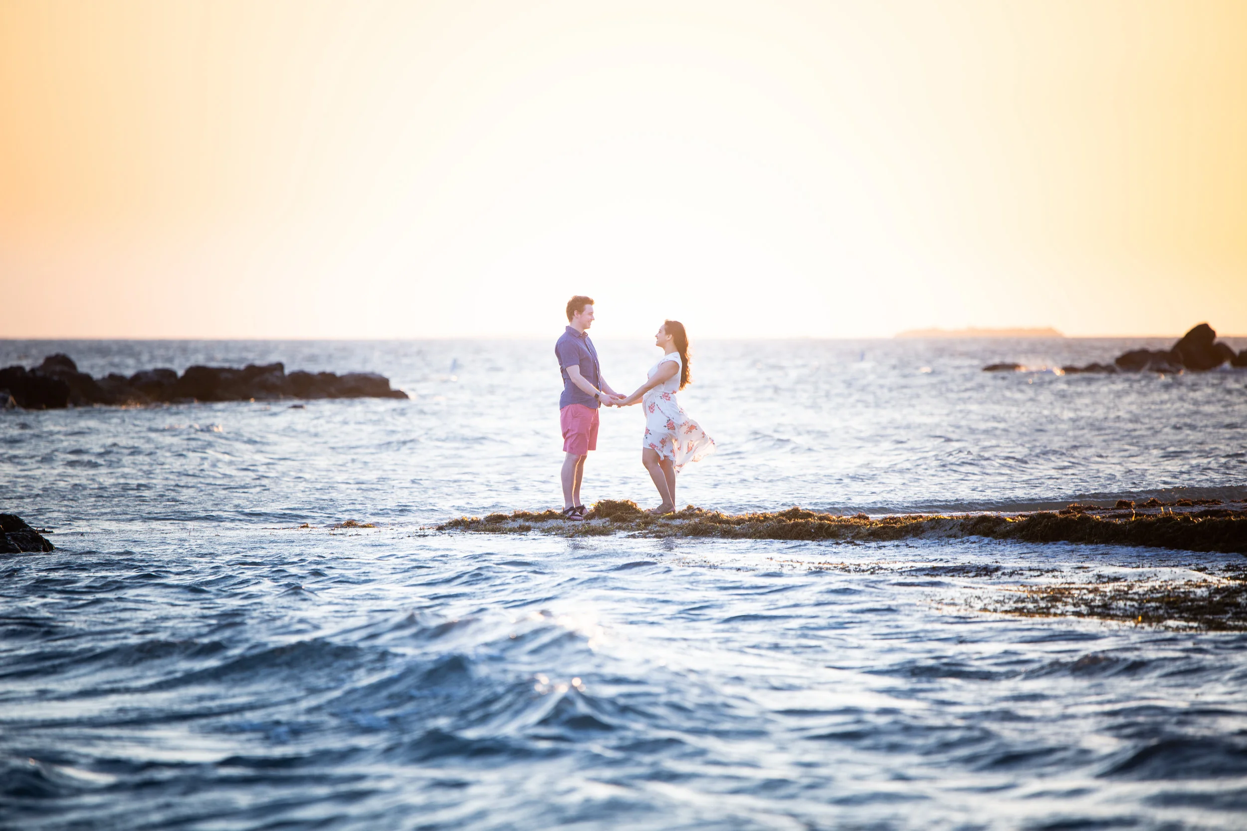Couple holding hands over water in Key West during Secret Engagement session.jpg
