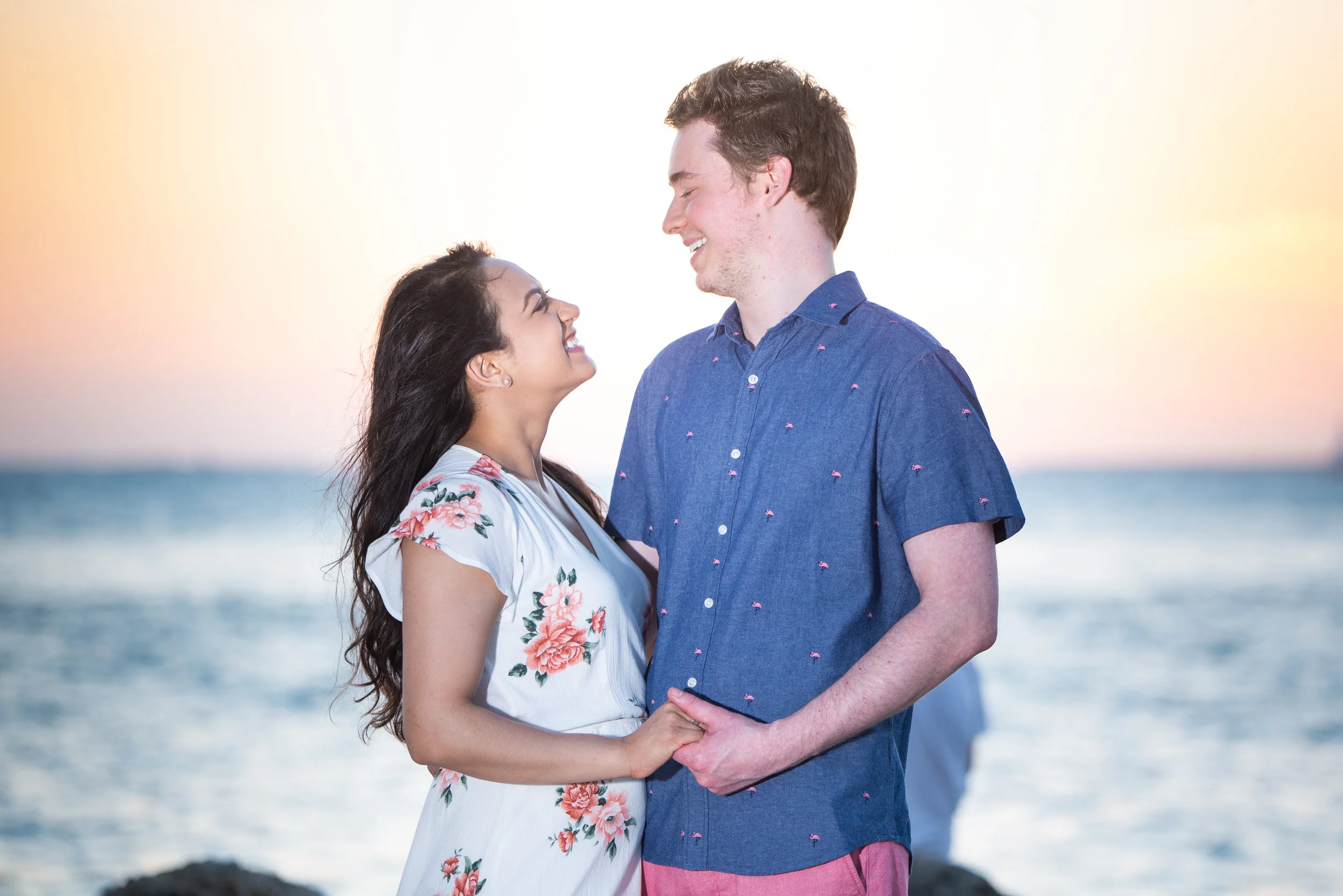 Couple smiling at each other with sunset in background.jpg