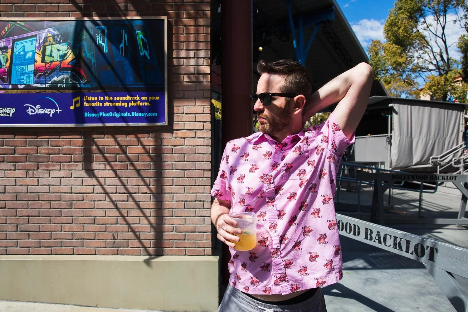 Man wearing a Bing Bong shirt holds a beer in California Adventure park.