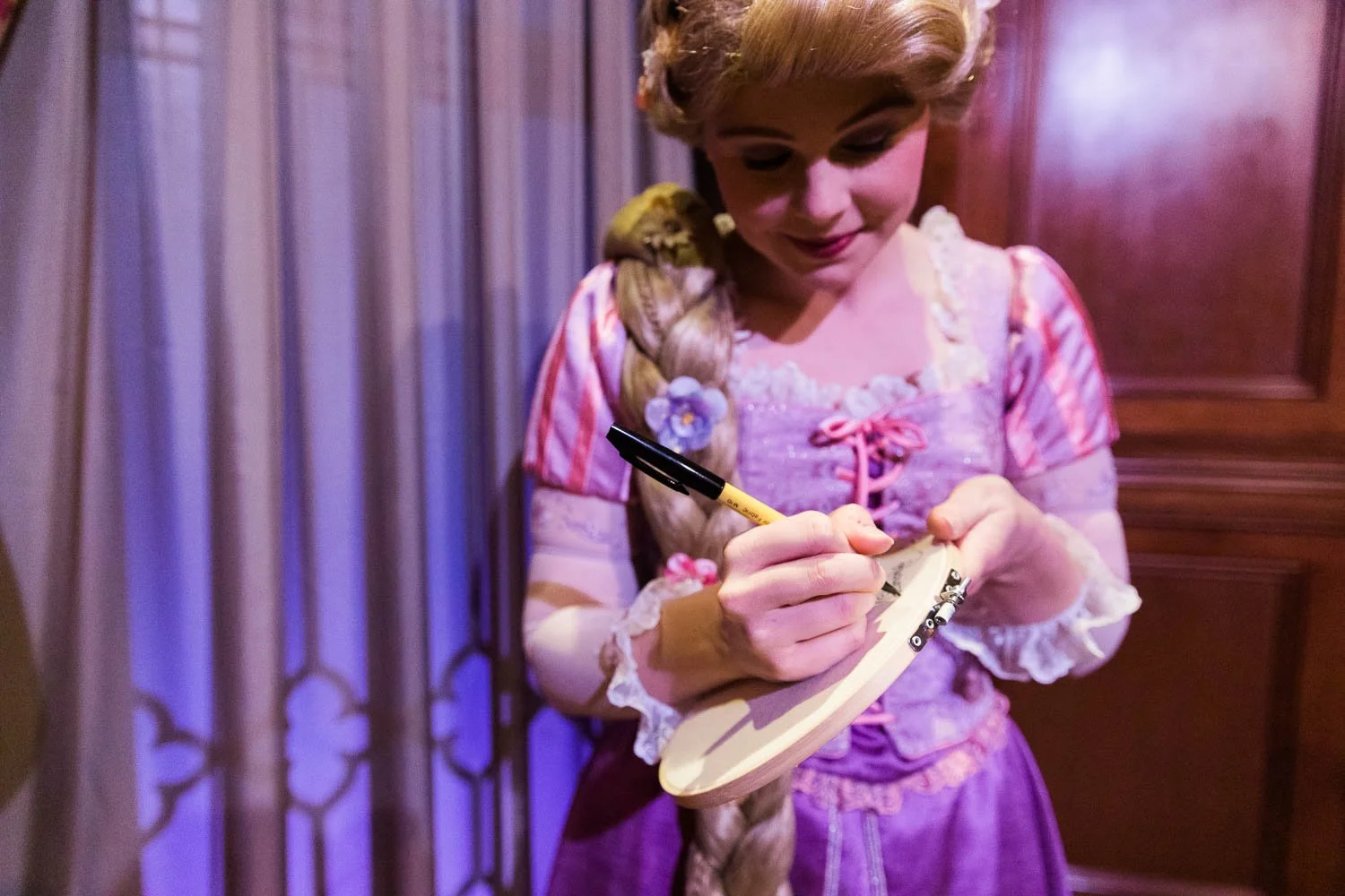 Rapunzel gives her autograph at the Magic Kingdom.