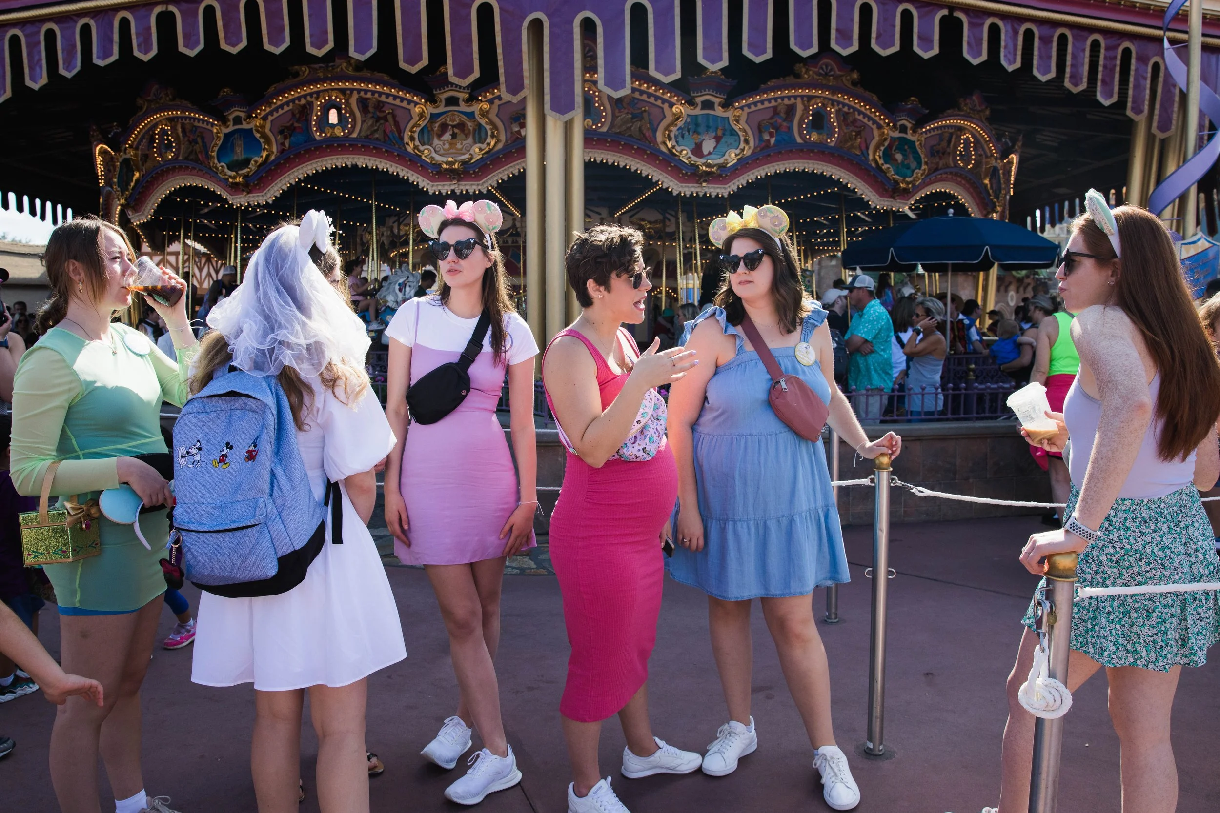 Young women wait for attractions in Fantasyland at Magic Kingdom.