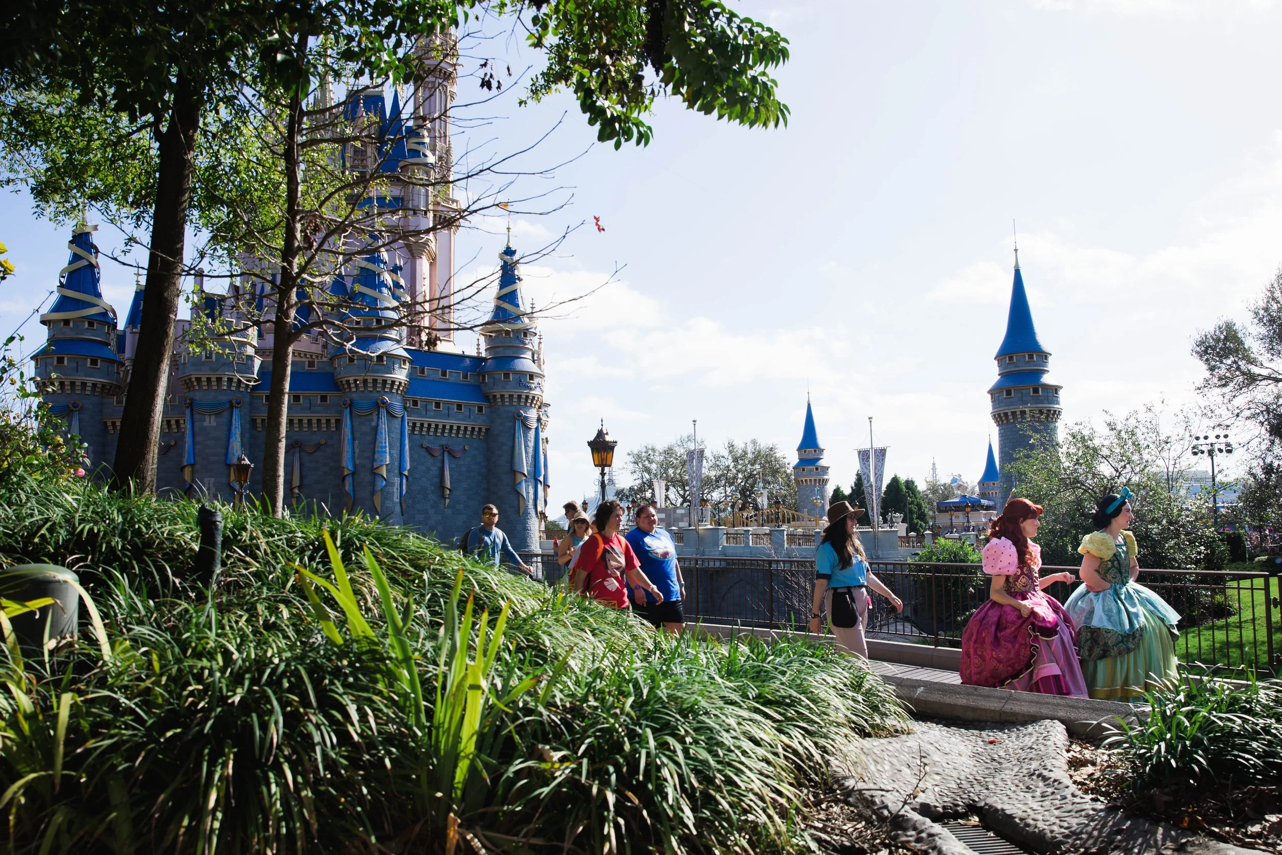 Anastasia and Drizella walk past Cinderella Castle at the Magic Kingdom.