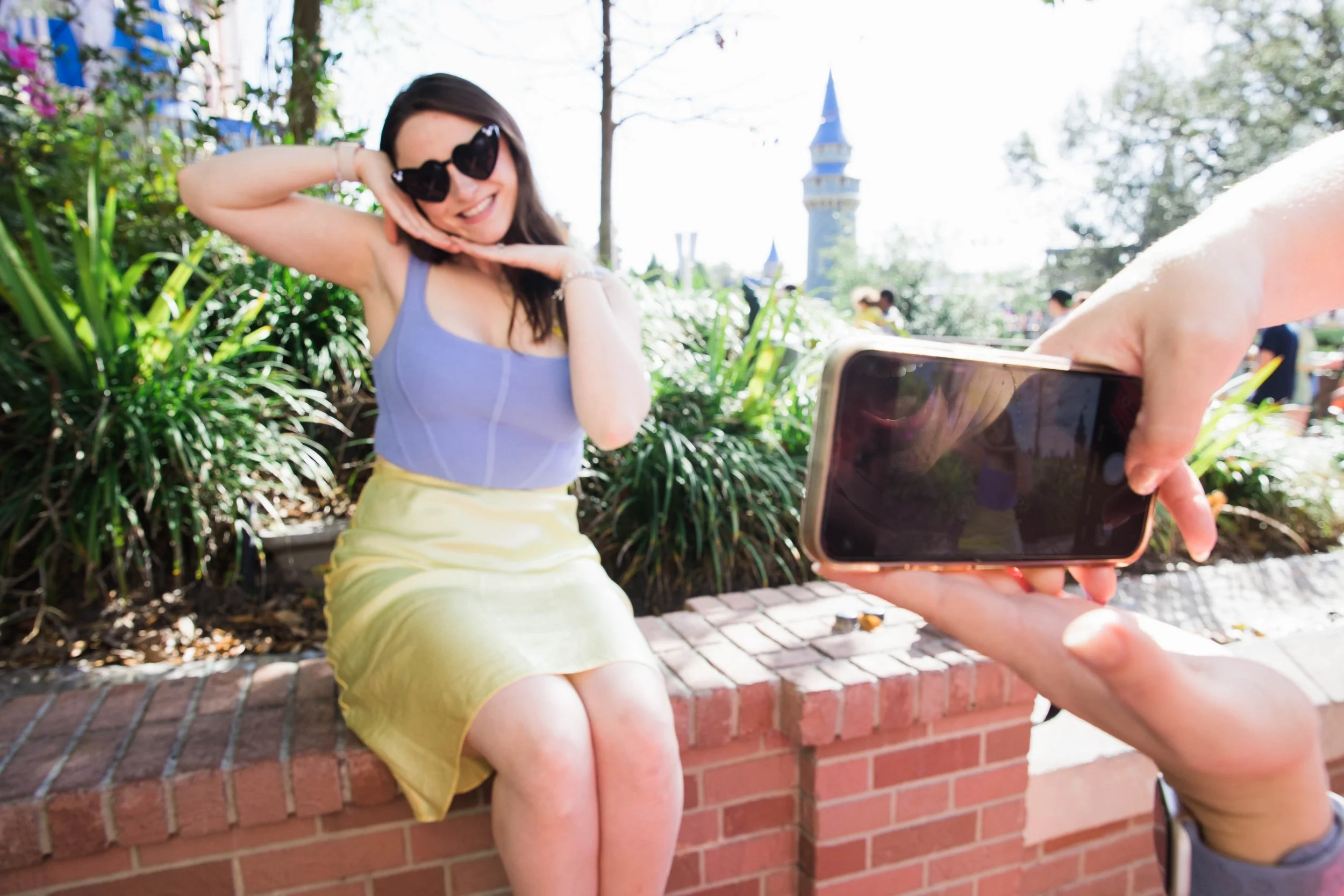 Girls take photos for Instagram in front of Cinderella Castle.