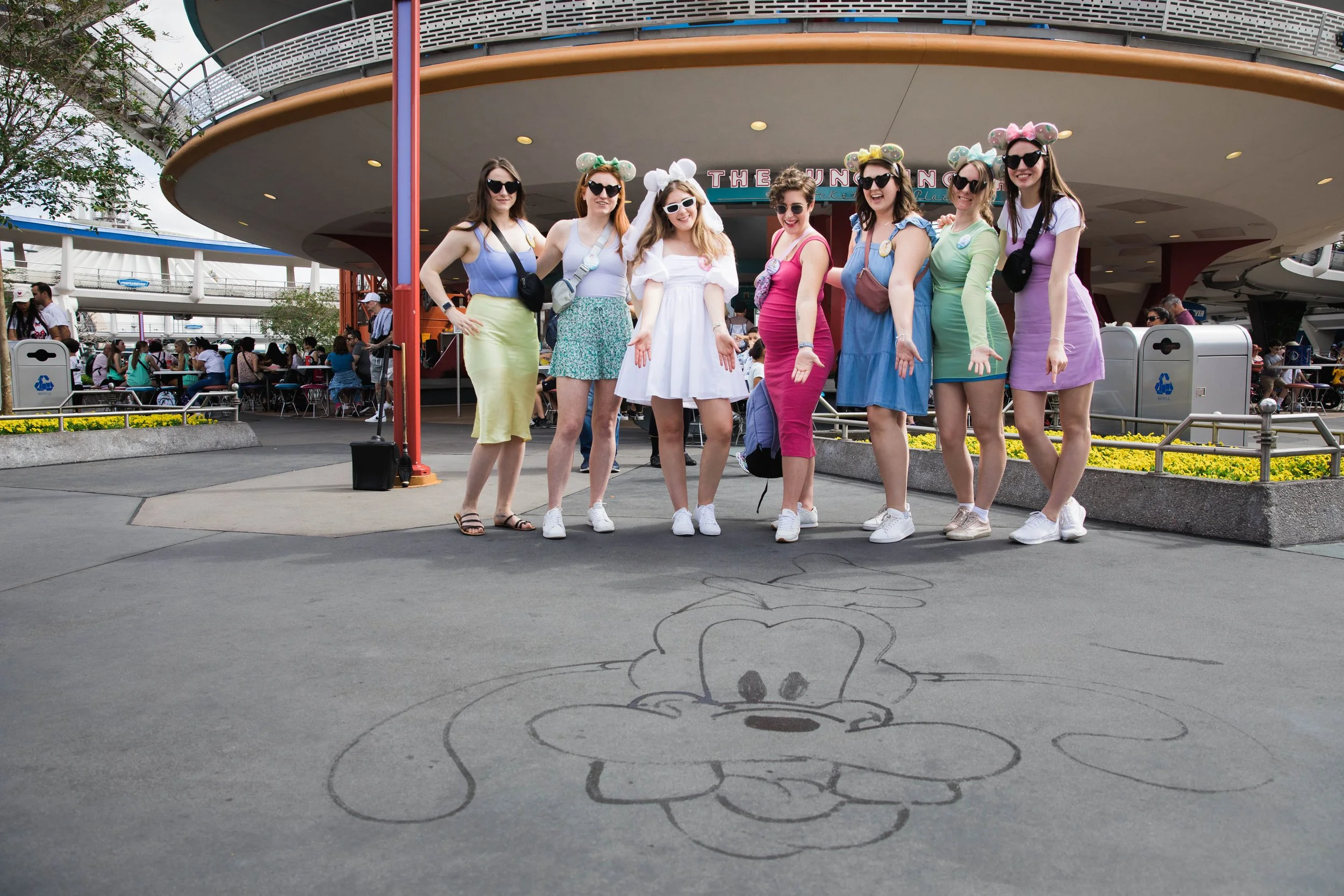 Young women admire Goofy art in Tomorrowland.