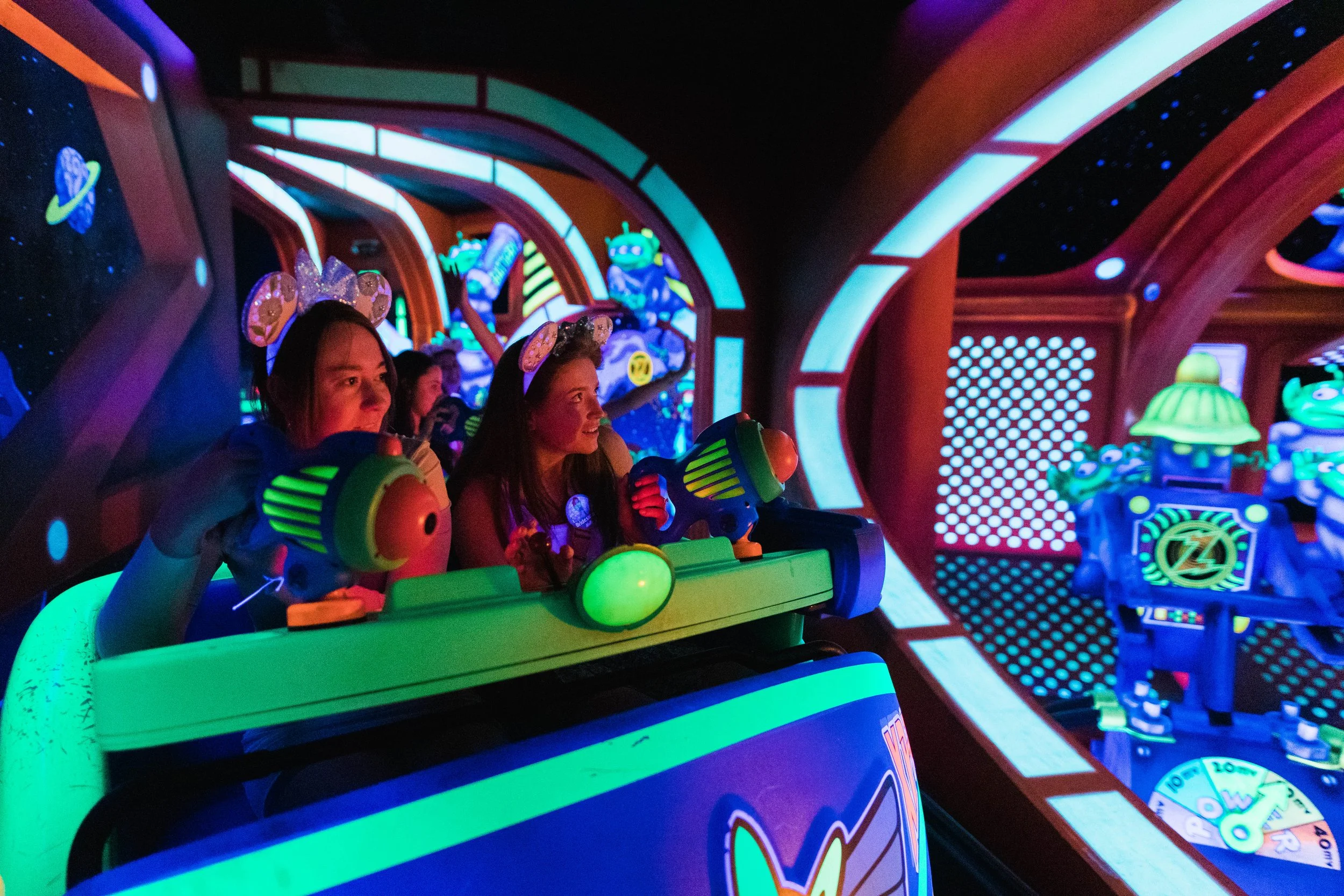 Young women ride Buzz Lightyear's Spaceranger Spin in Tomorrowland.