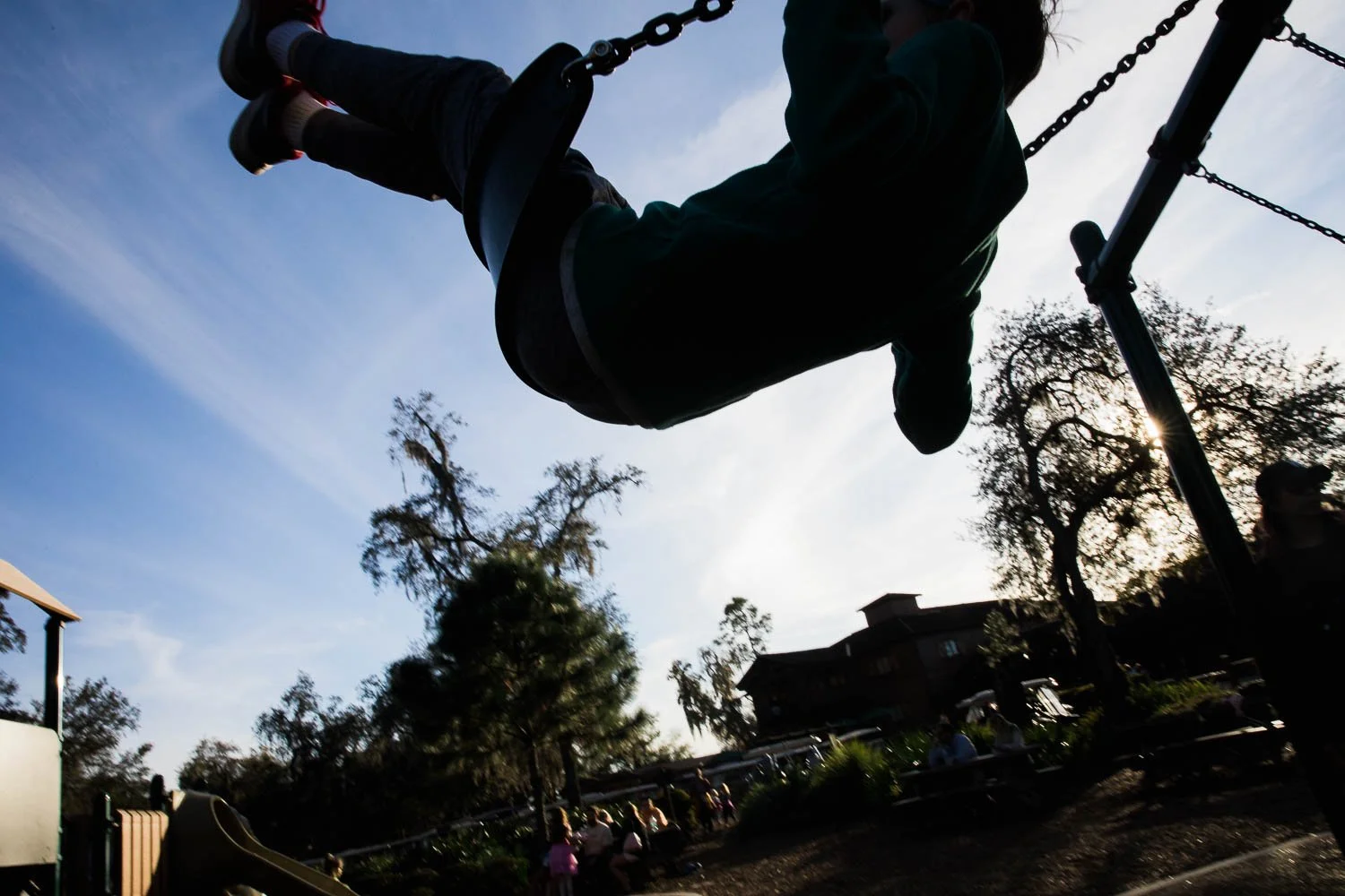 Silhouette of a boy swinging at Fort Wilderness campground.