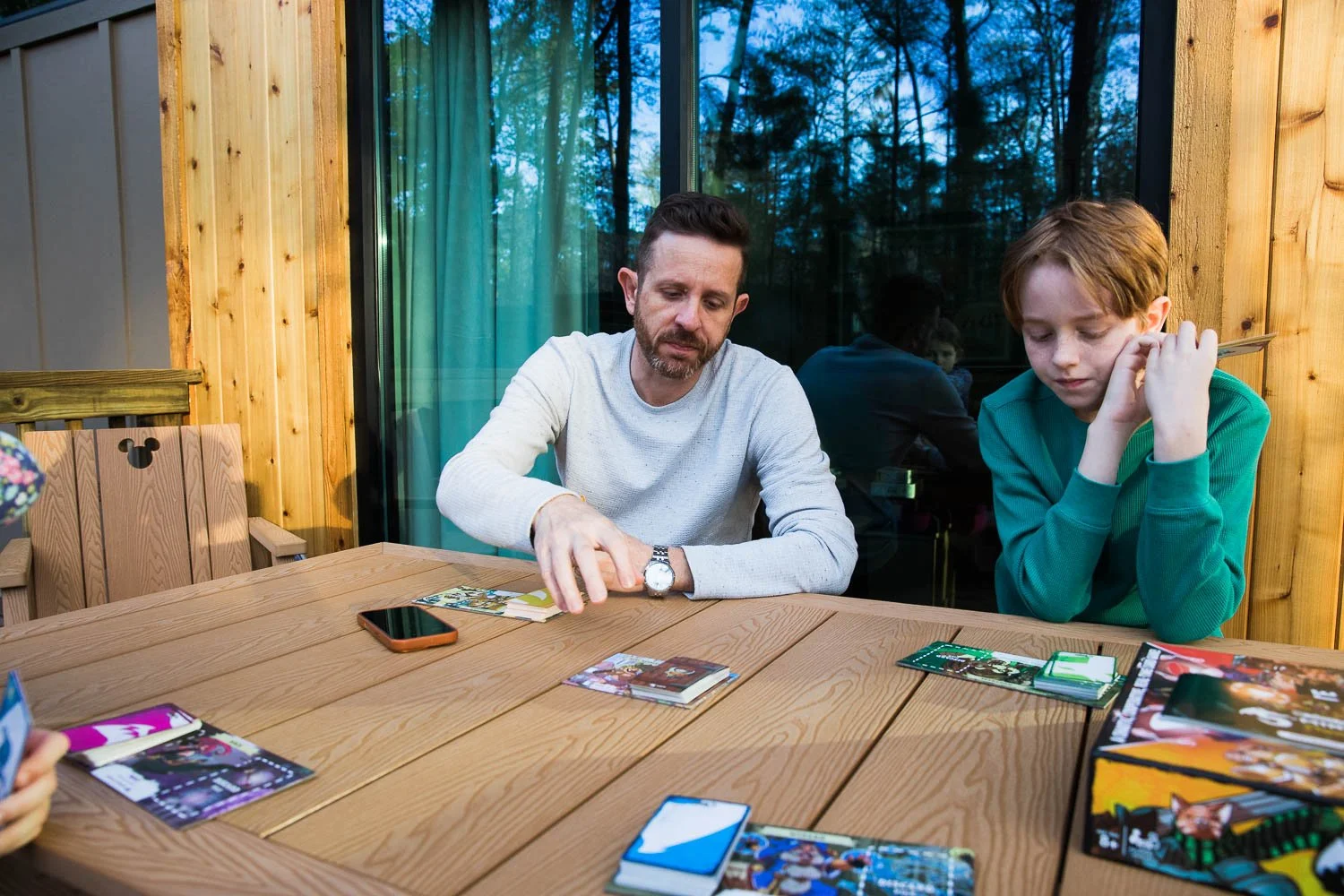 Family plays games on the picnic table of their DVC cabin at Fort Wilderness Resort in Orlando, Florida.