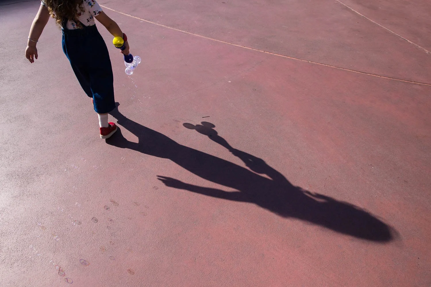 Silhouette of a little girl with a bubble wand at Magic Kingdom.