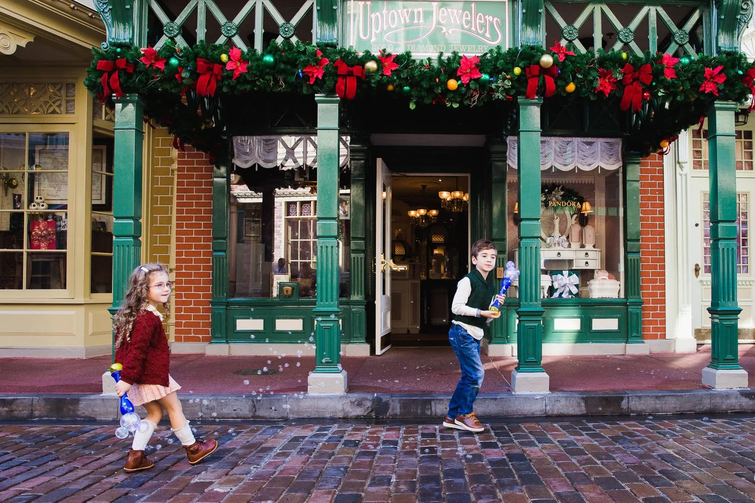 Siblings play with bubble wands on Main Street USA in the Magic Kingdom.