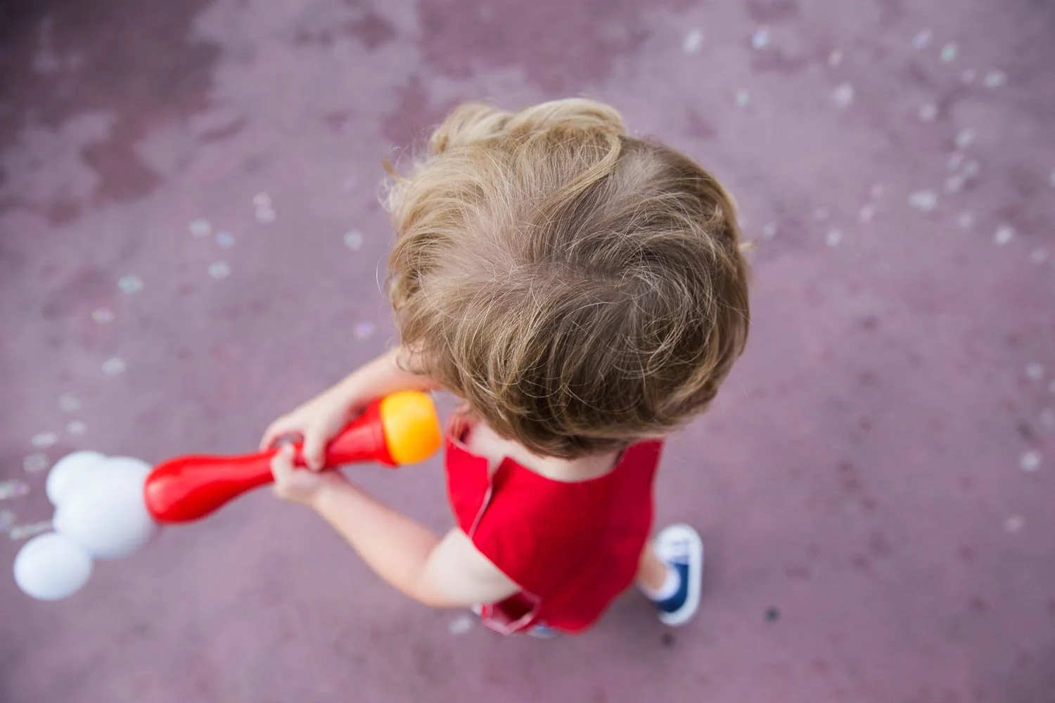 Up close photo of a little boy with a bubble wand at Disney World.