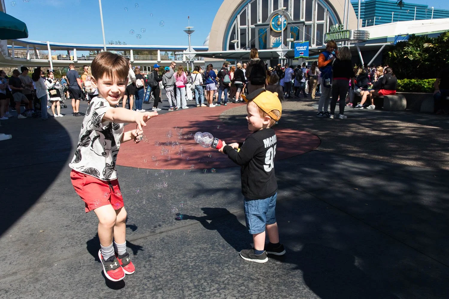 Boys play with bubbles in Tomorrowland at Walt Disney World.