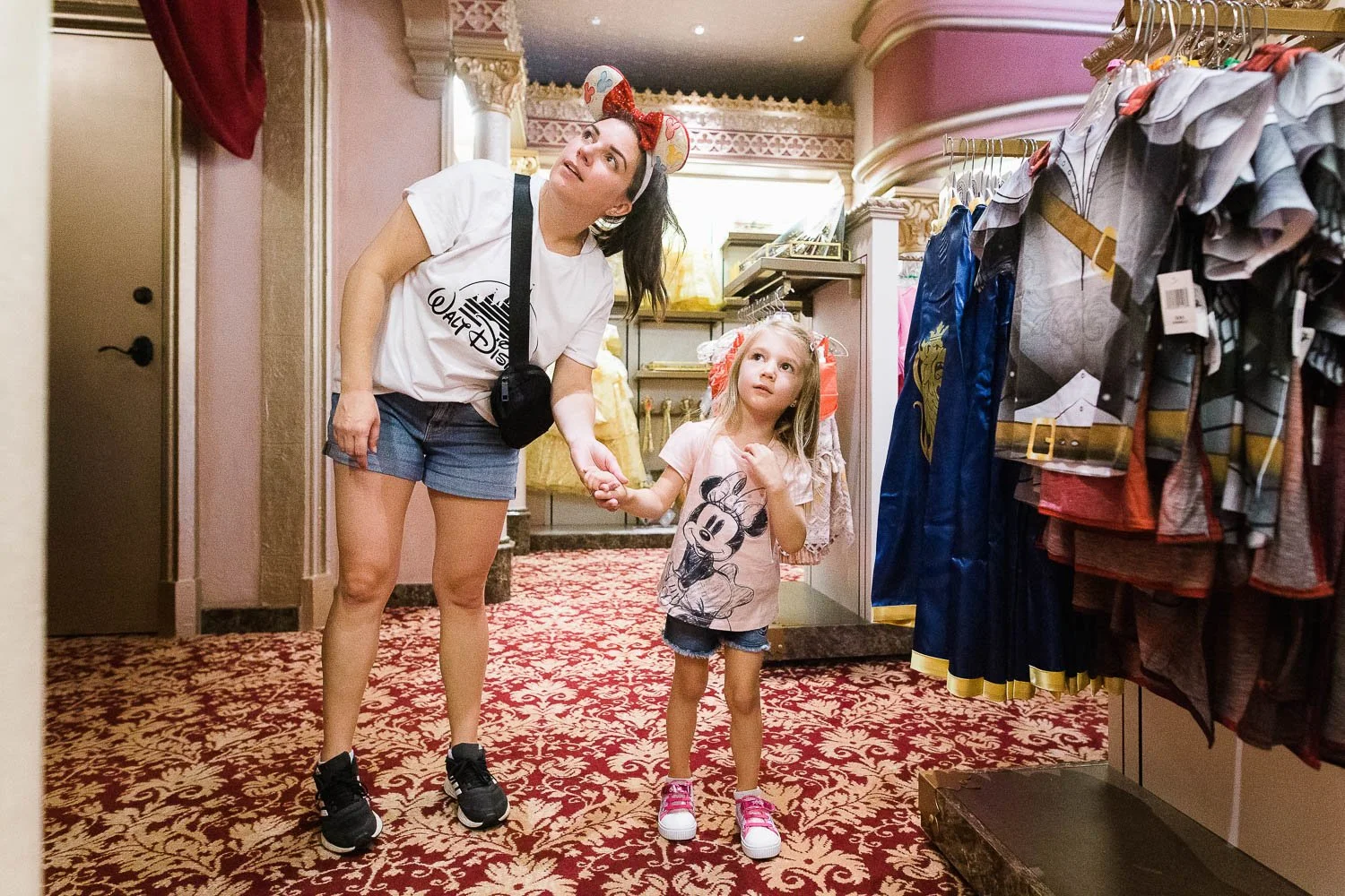 Mother and daughter look at princess dresses at the Bibbidi Bobbidi Boutique in Magic Kingdom.