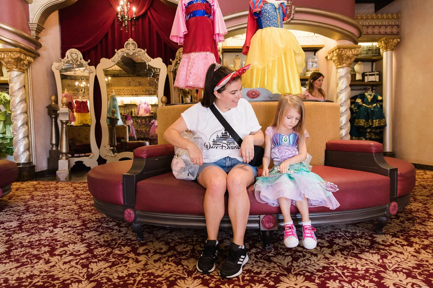 Mother and daughter wait at the Bibbidi Bobbidi Boutique.