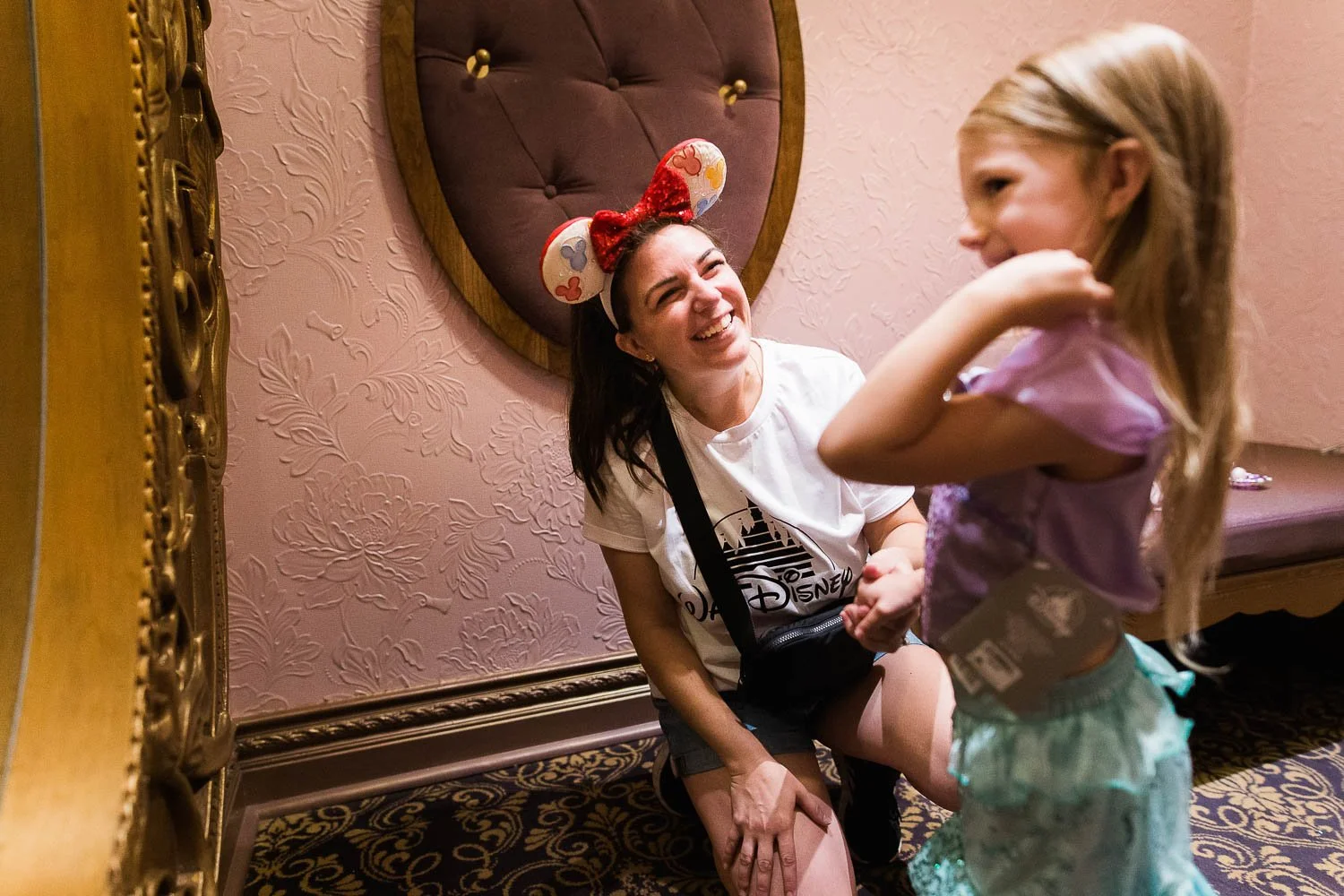 Little girl tries on Princess Ariel dress at Bibbidi Bobbidi Boutique.
