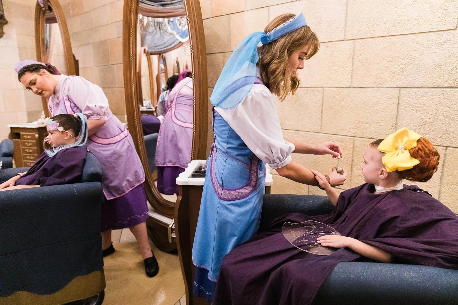 Fairy Godmother paints little girl's nails at Bibbidi Bobbidi Boutique.