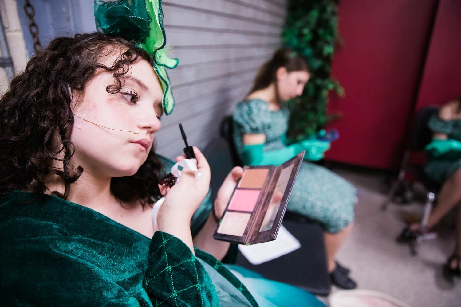 Ozians put on make up backstage of the Wizard of Oz.