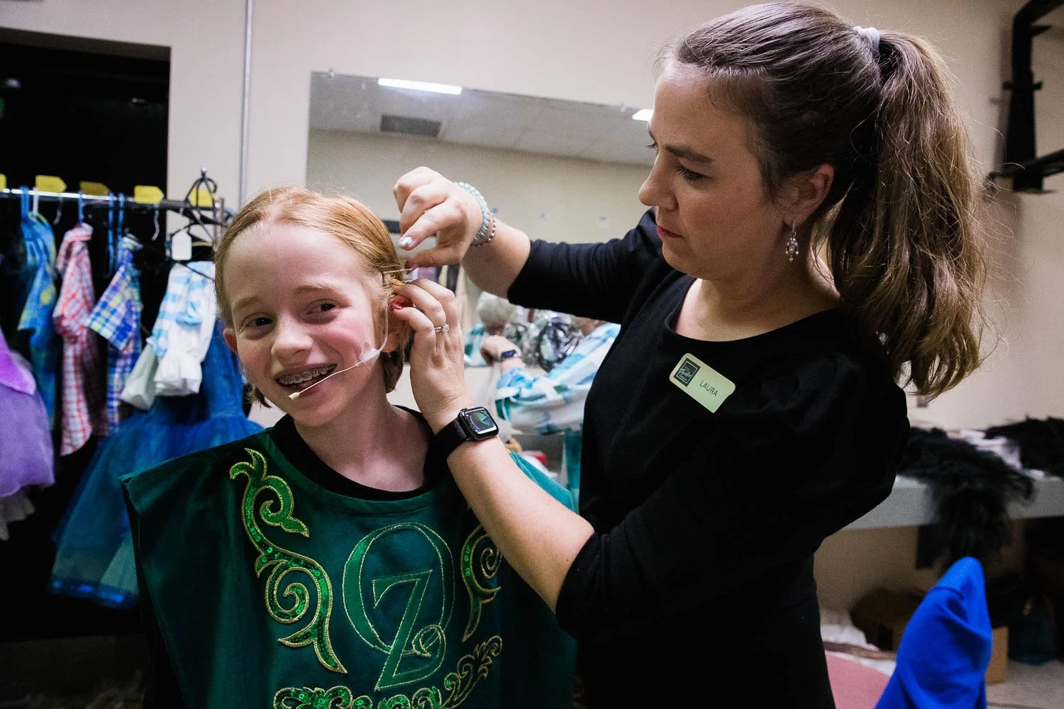Volunteer helps an Oz guard backstage for the Wizard of Oz.