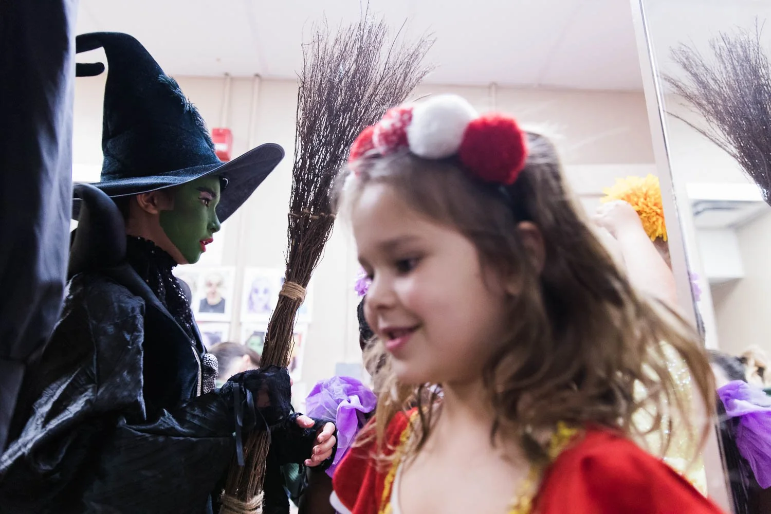 The Wicked Witch walks past lullaby league kids backstage.