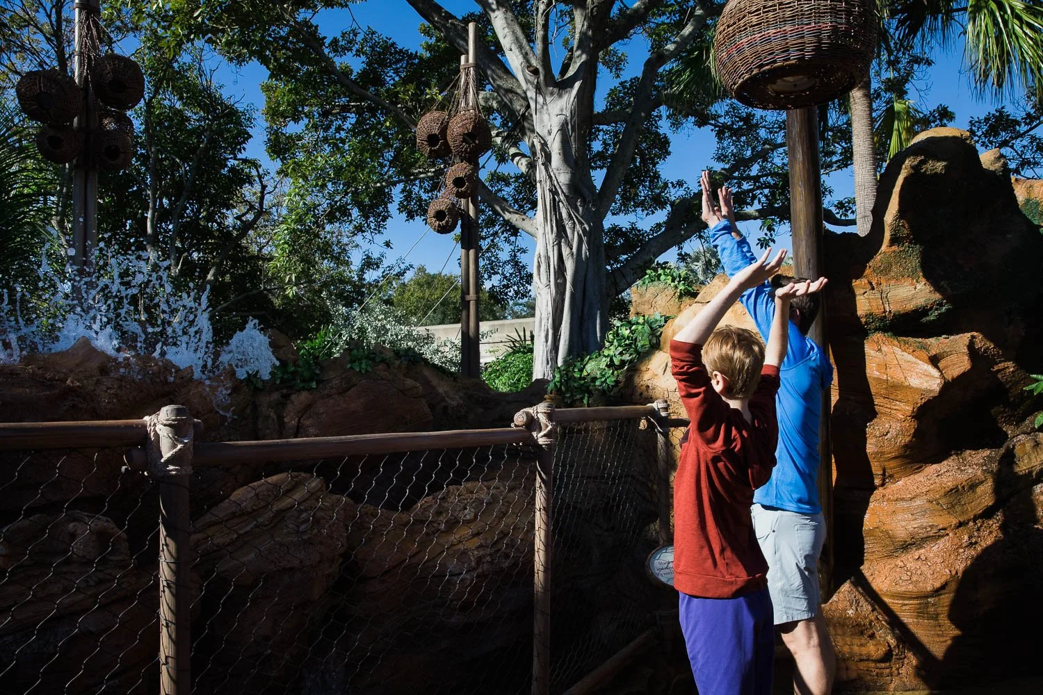 Father and son make water jump at Journey into Water with Moana in Epcot.