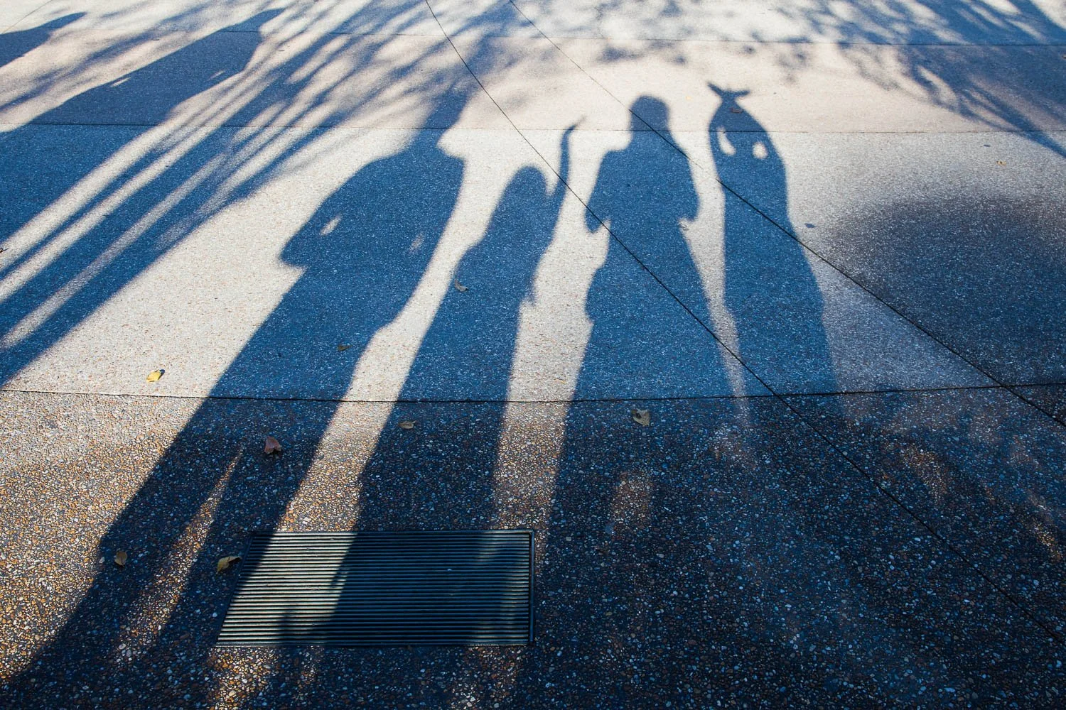 A family's shadows on the ground of Future World at Epcot.